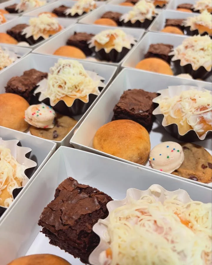 Assorted Filipino desserts in boxes including brownies and leche flan