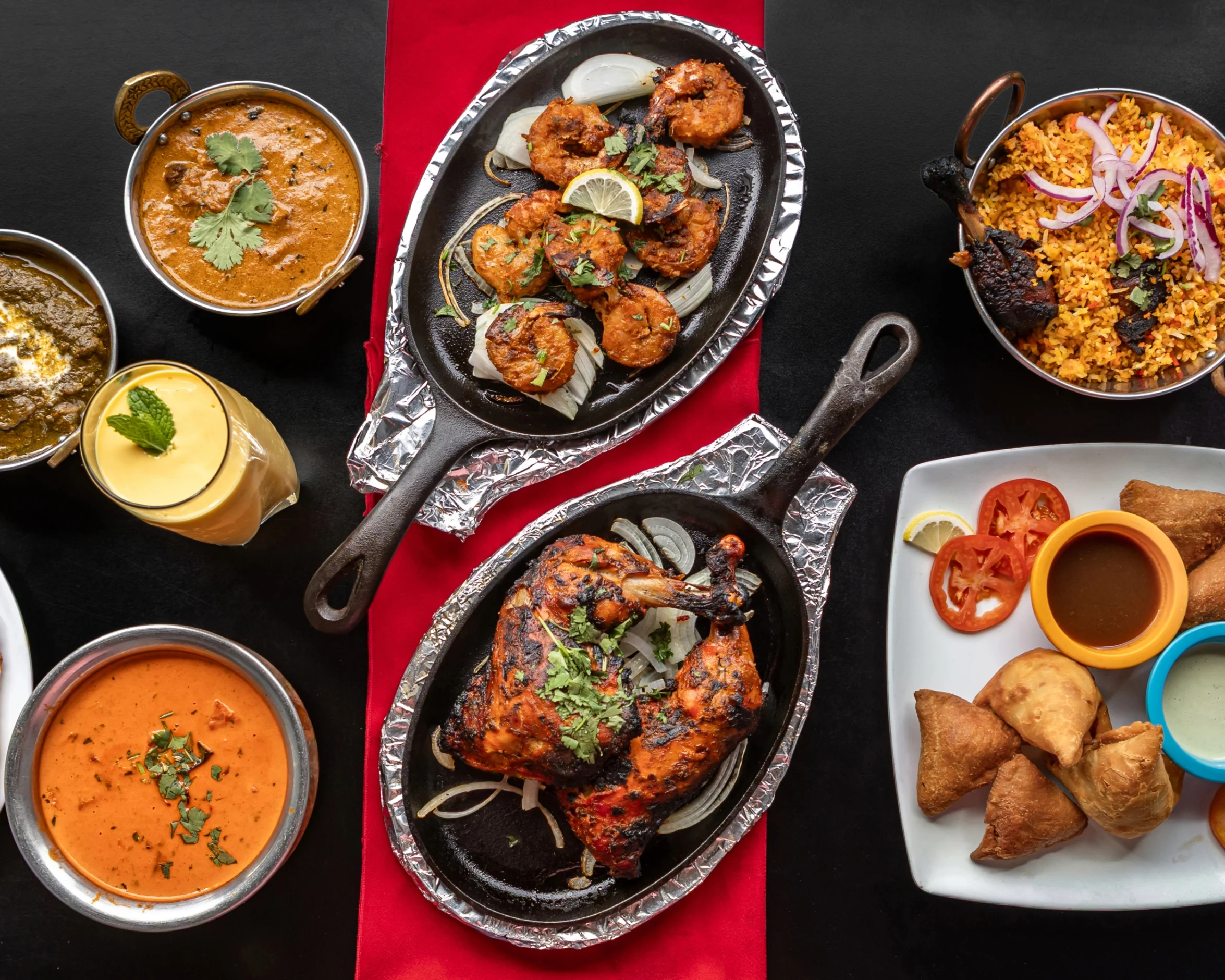 Sizzling Indian tandoori chicken with biryani and samosas