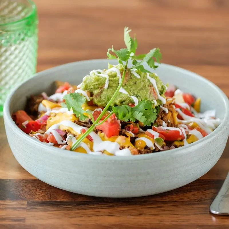 Colorful Mexican burrito bowl with guacamole and fresh toppings