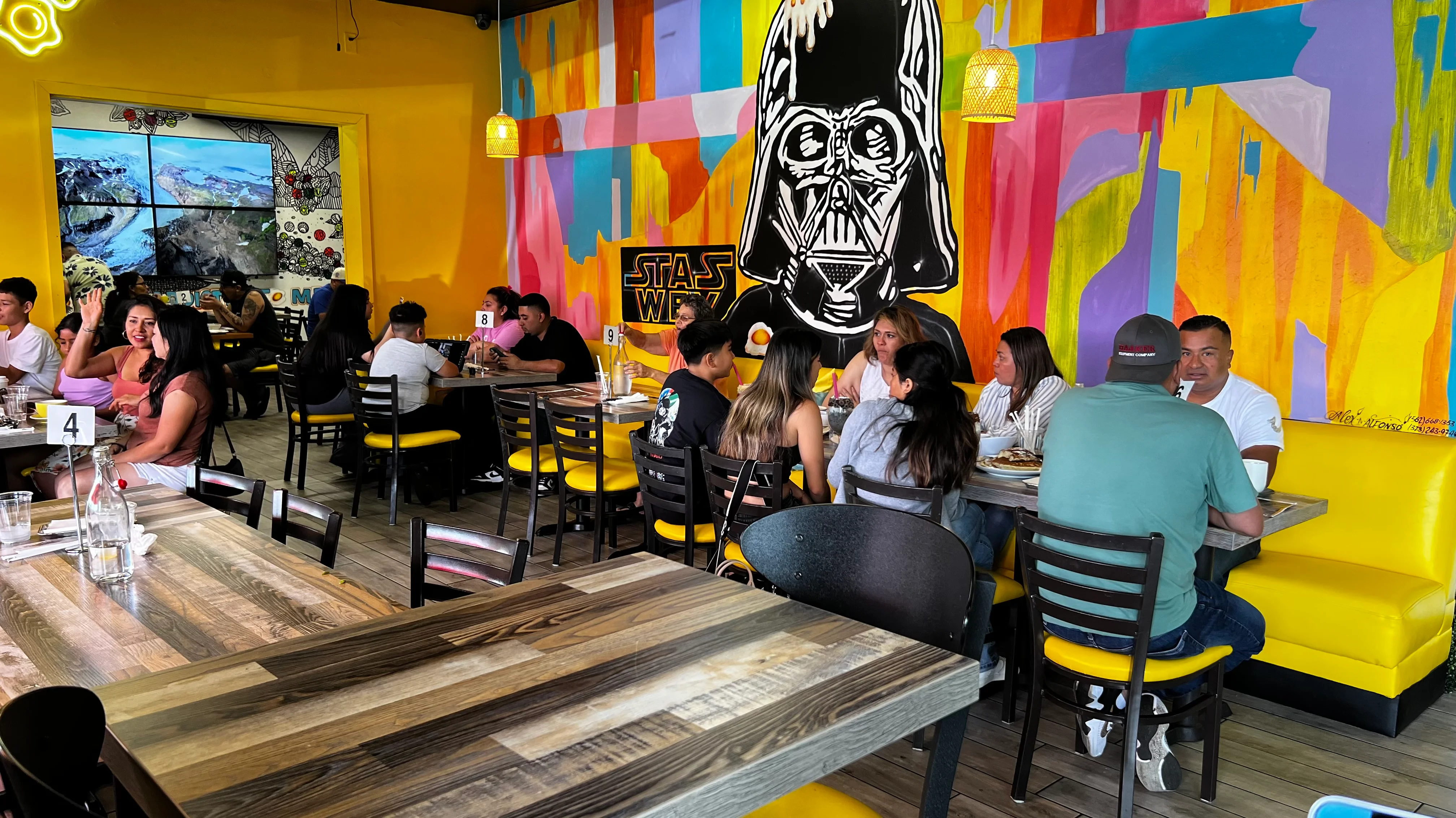 Vibrant restaurant interior with colorful mural and diners