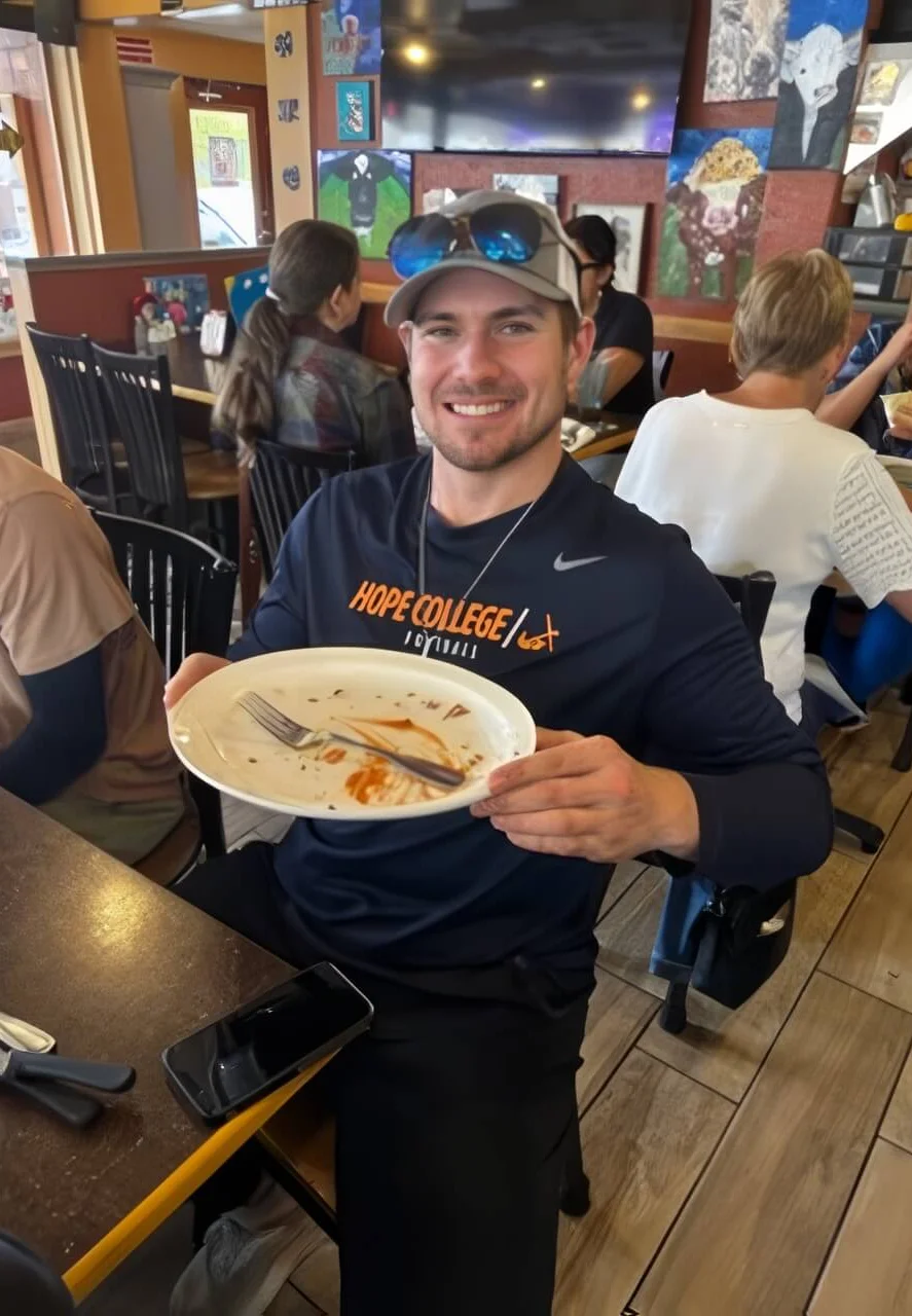Smiling diner holding an empty plate in a casual restaurant setting