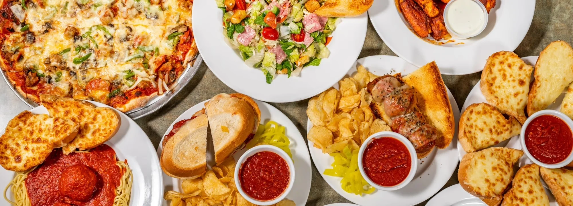 Italian feast with pizza, pasta, and garlic bread