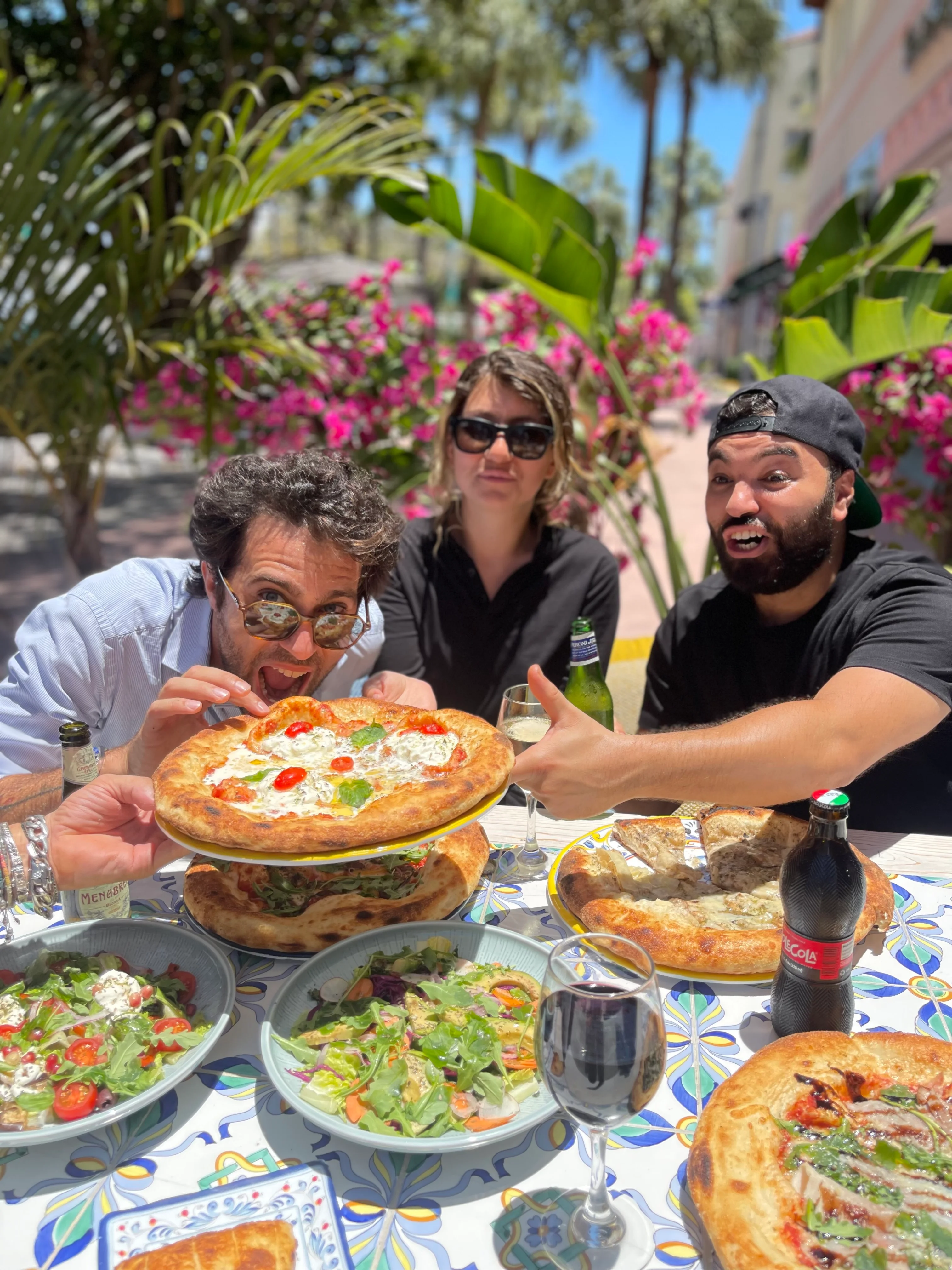 Group enjoying Neapolitan pizza at a vibrant outdoor setting