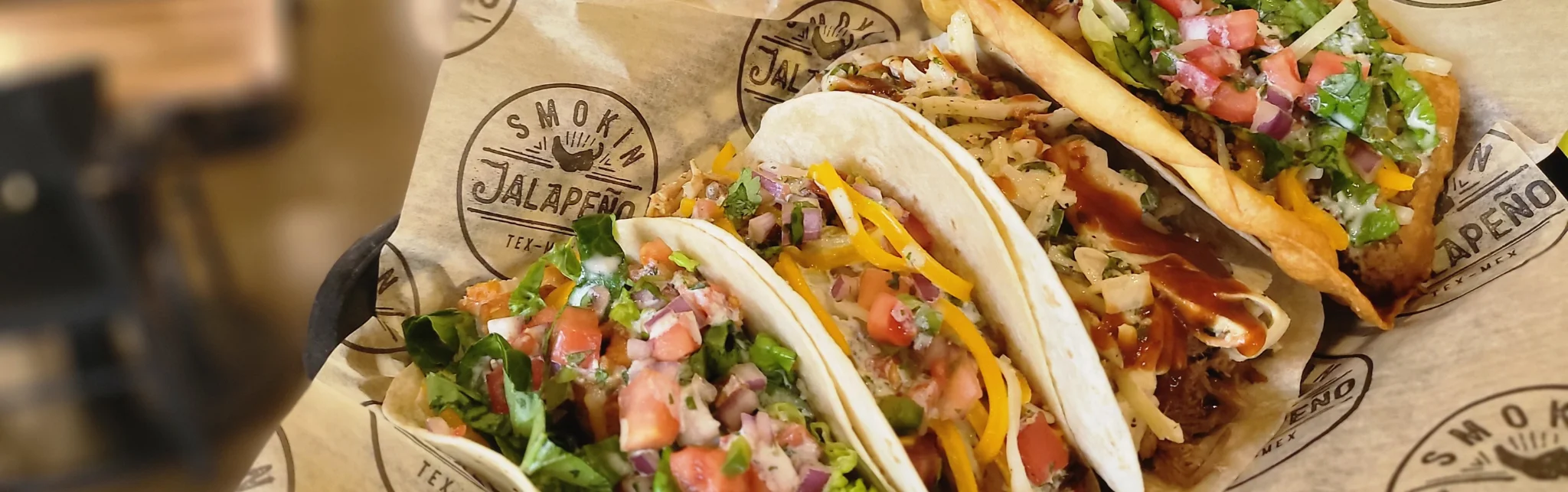 Three Tex-Mex tacos with fresh toppings