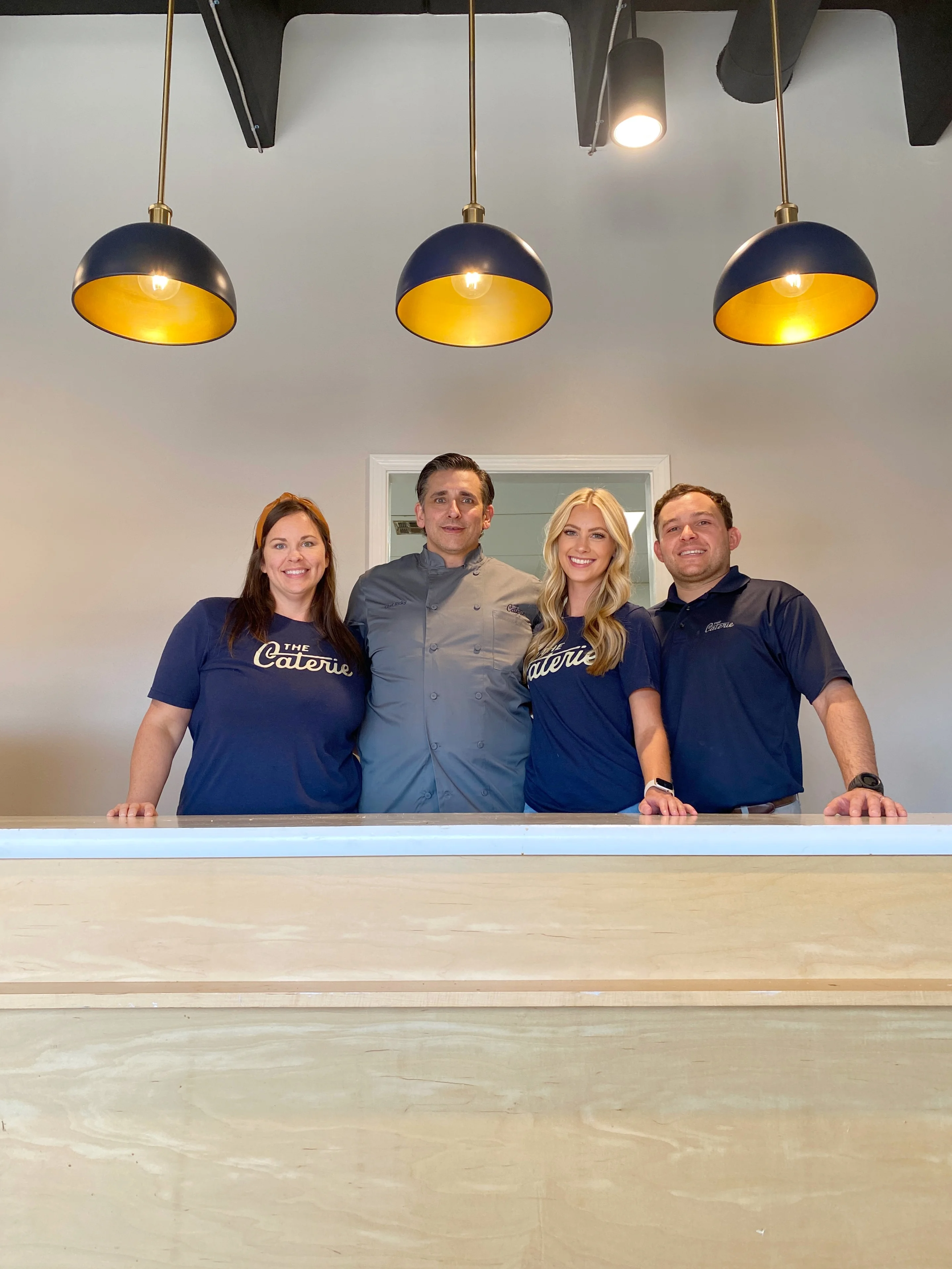 Restaurant team posing at the counter in a modern dining space