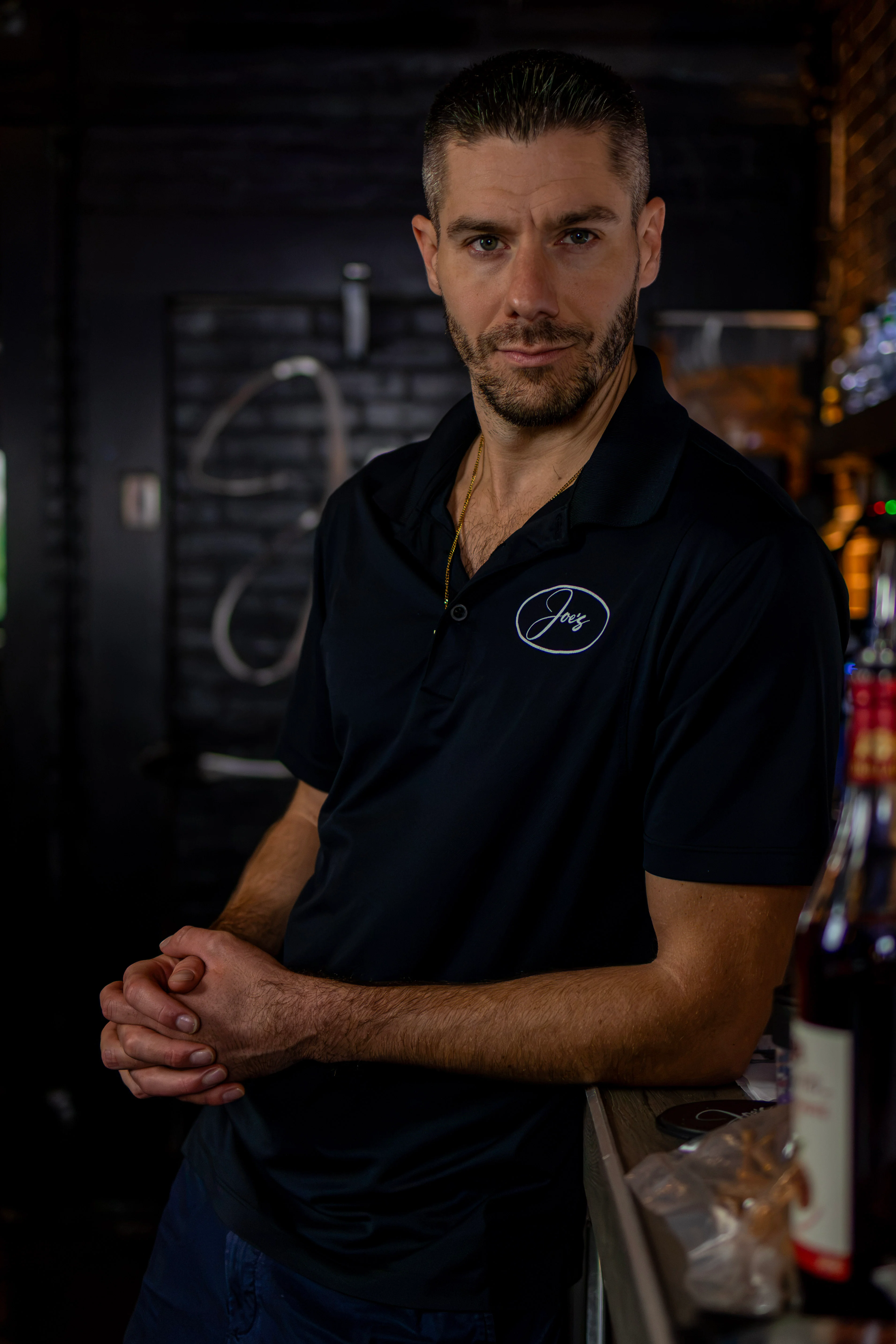 Chef portrait in a dimly lit restaurant kitchen