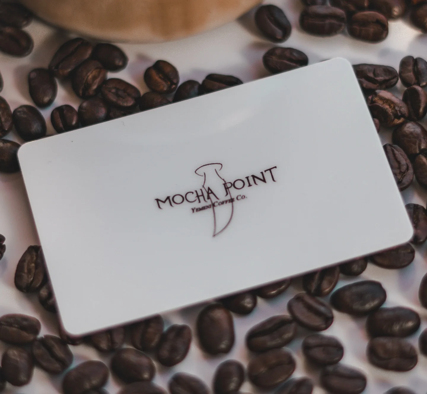 Mocha Point coffee gift card on roasted coffee beans