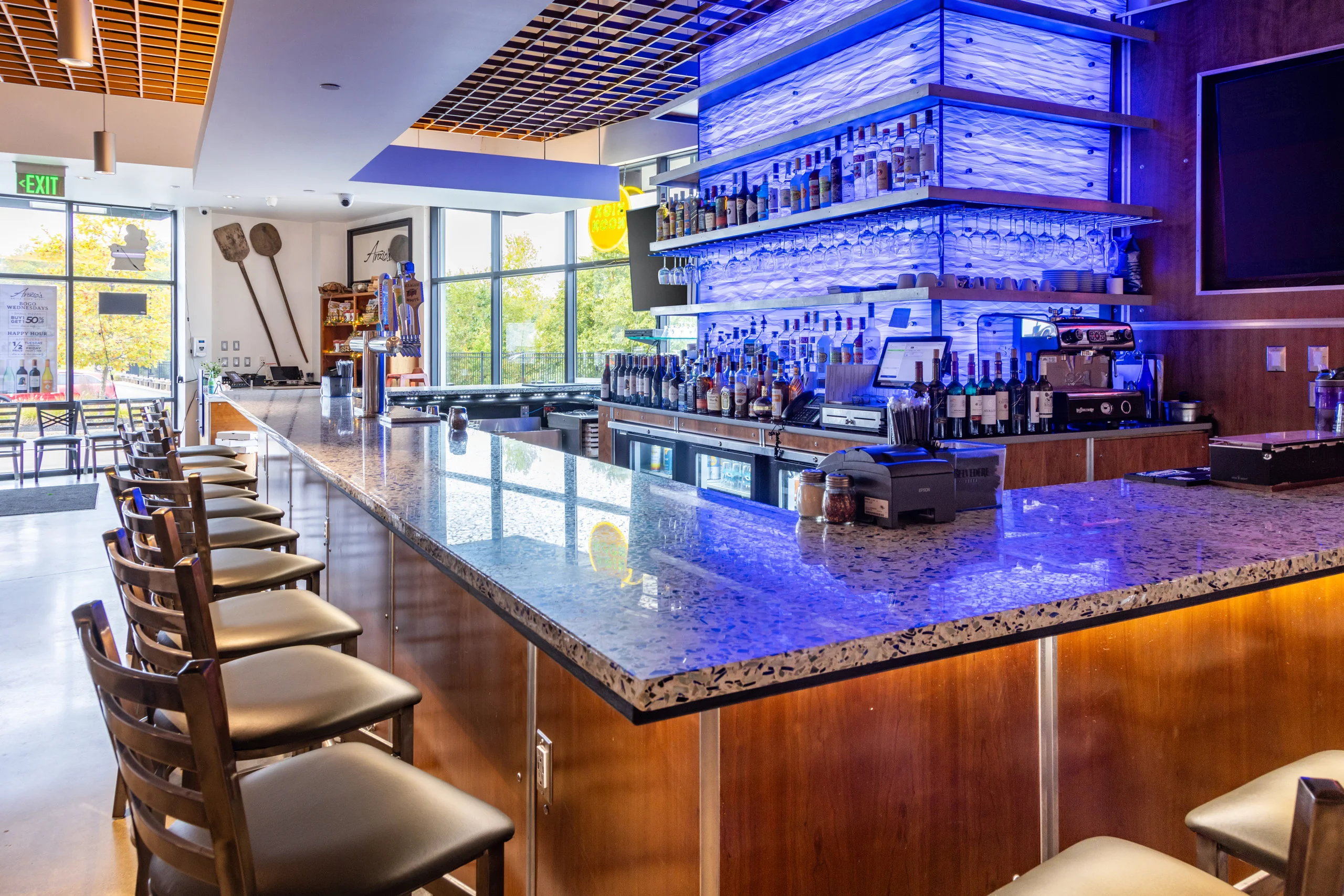 Modern bar interior with illuminated shelves and seating