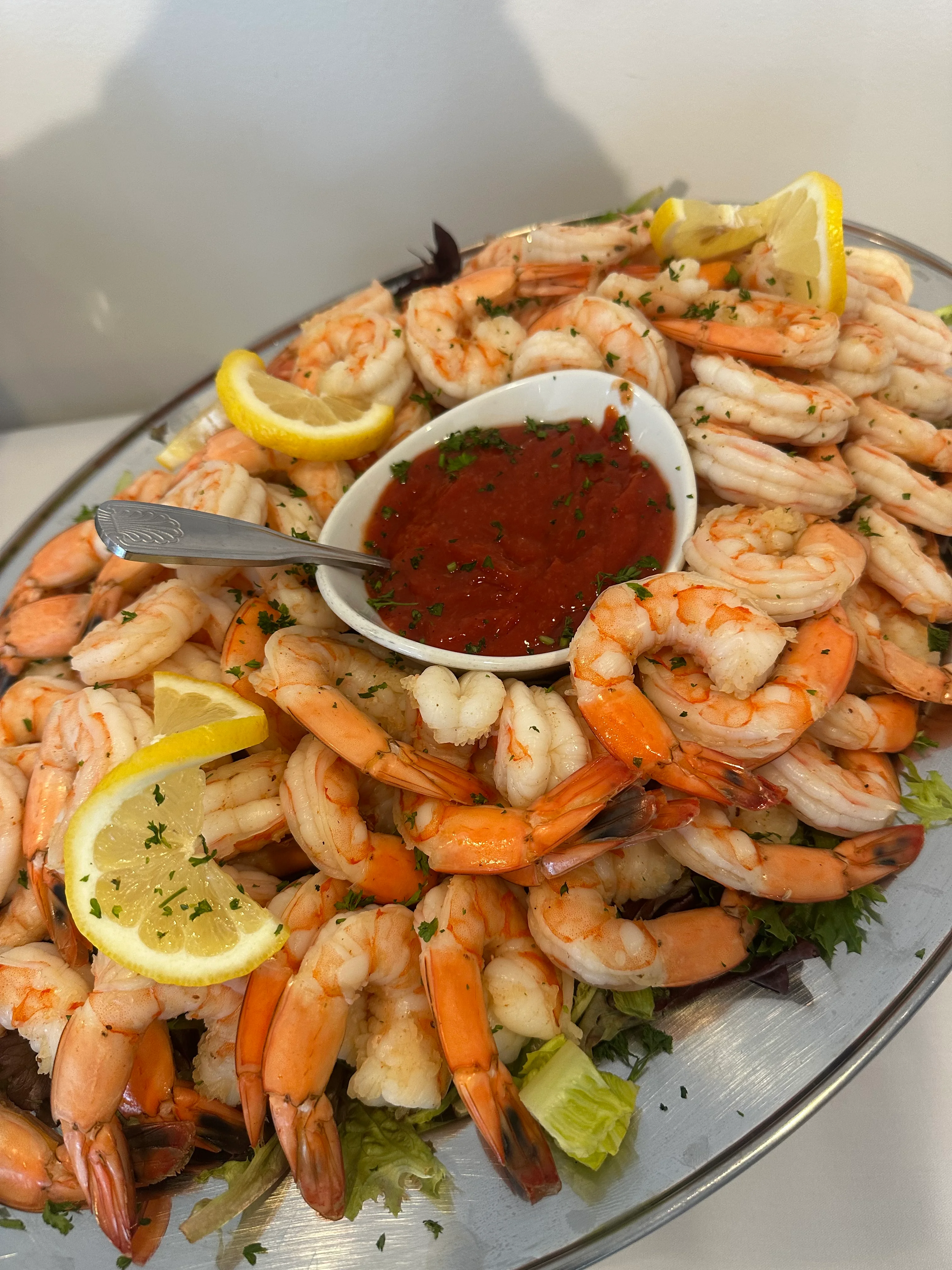 Platter of shrimp with cocktail sauce and lemon slices