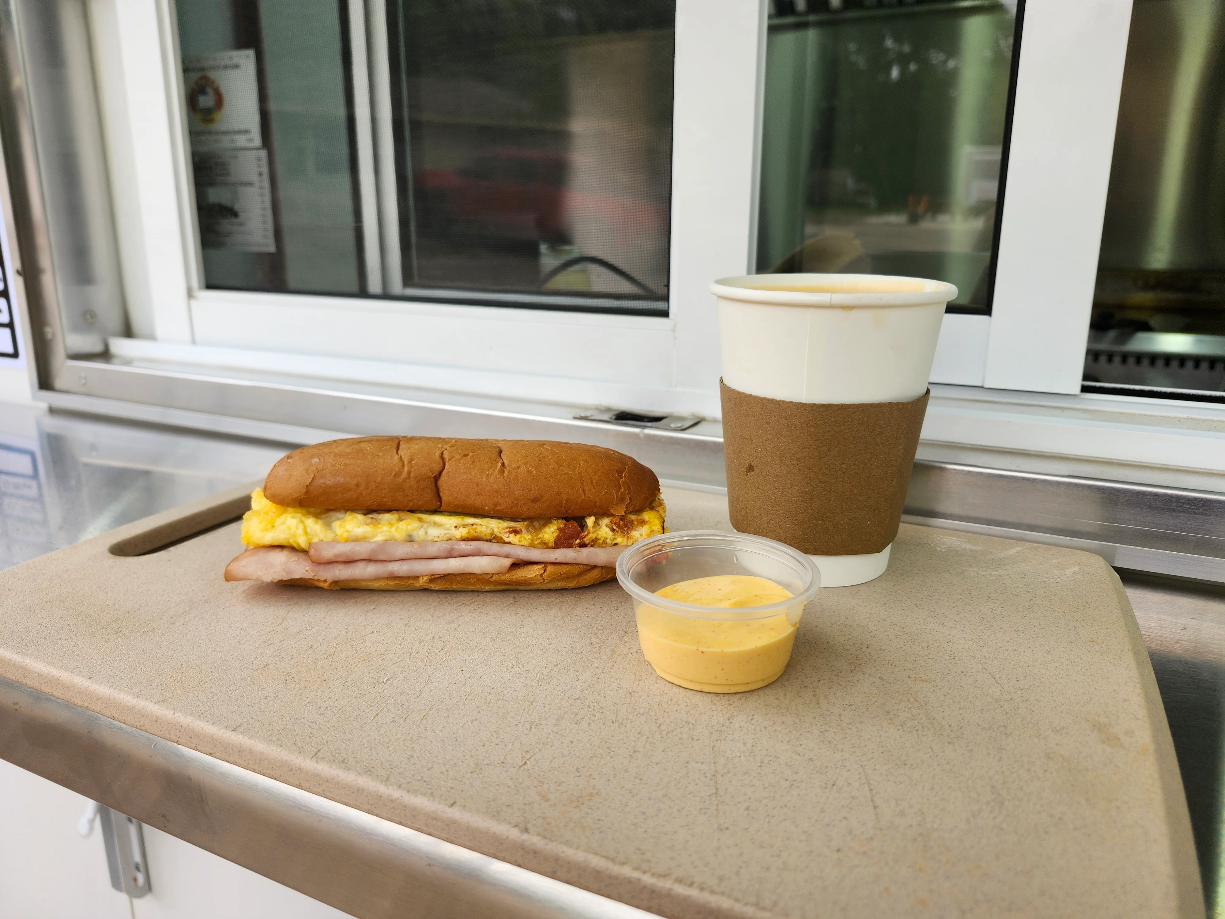 Breakfast sandwich with egg and ham on a toasted bun