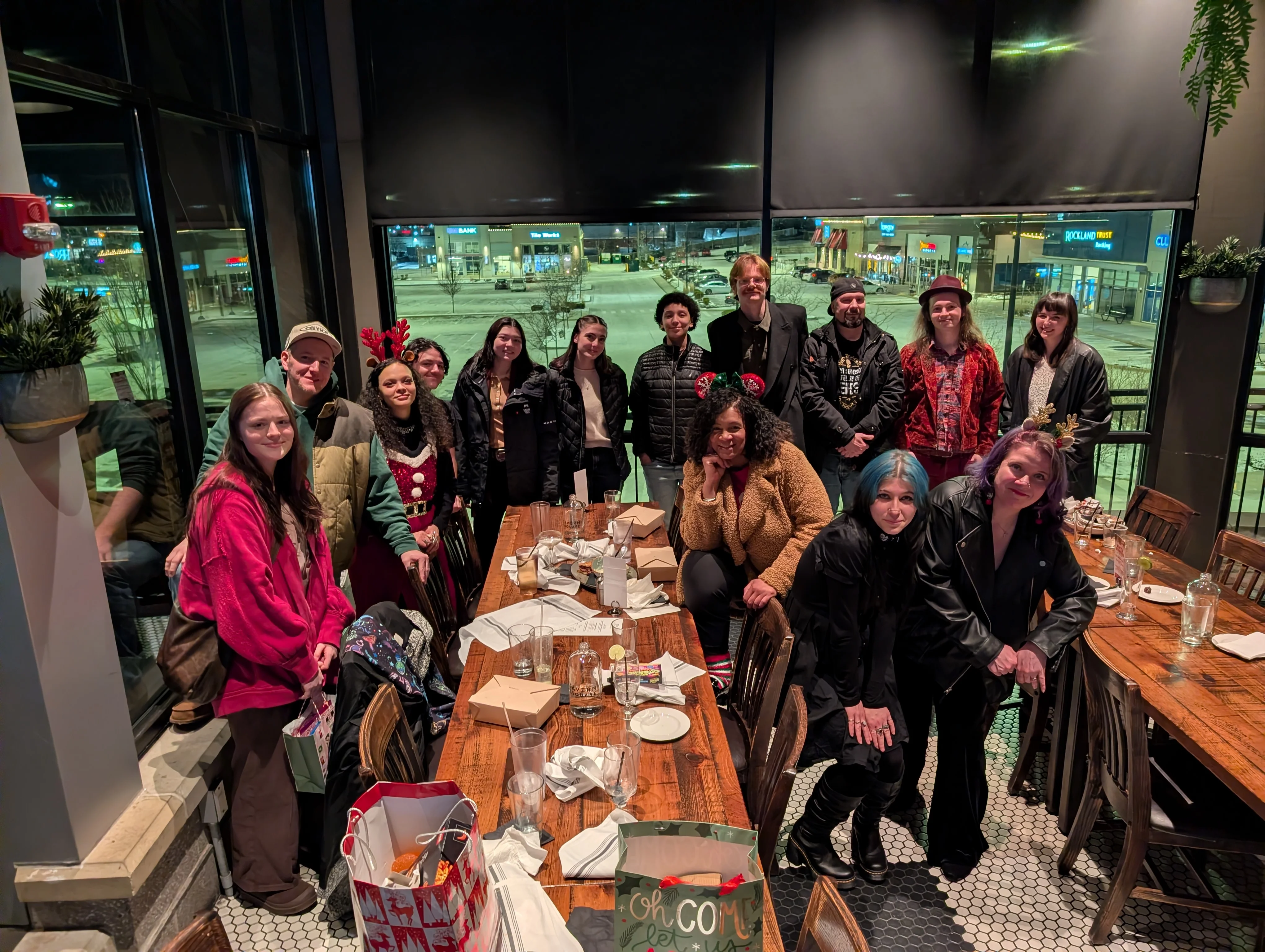 Group of friends celebrating at a restaurant with festive decor and a cozy atmosphere.