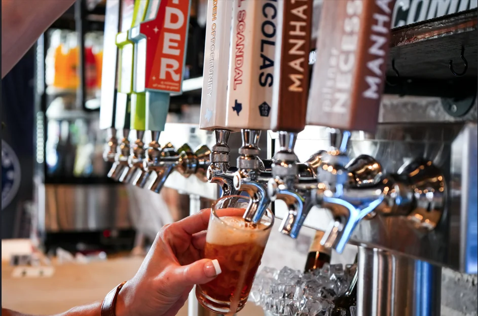Beer Taps pouring an amber ale beer into a pint glass.  