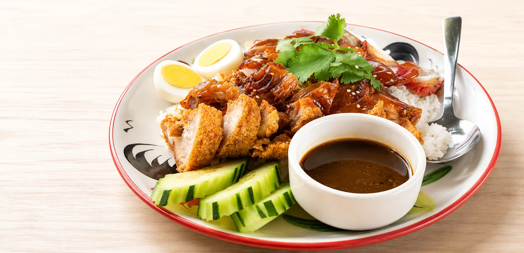 Crispy chicken rice with sauce and cucumber, a popular Asian dish