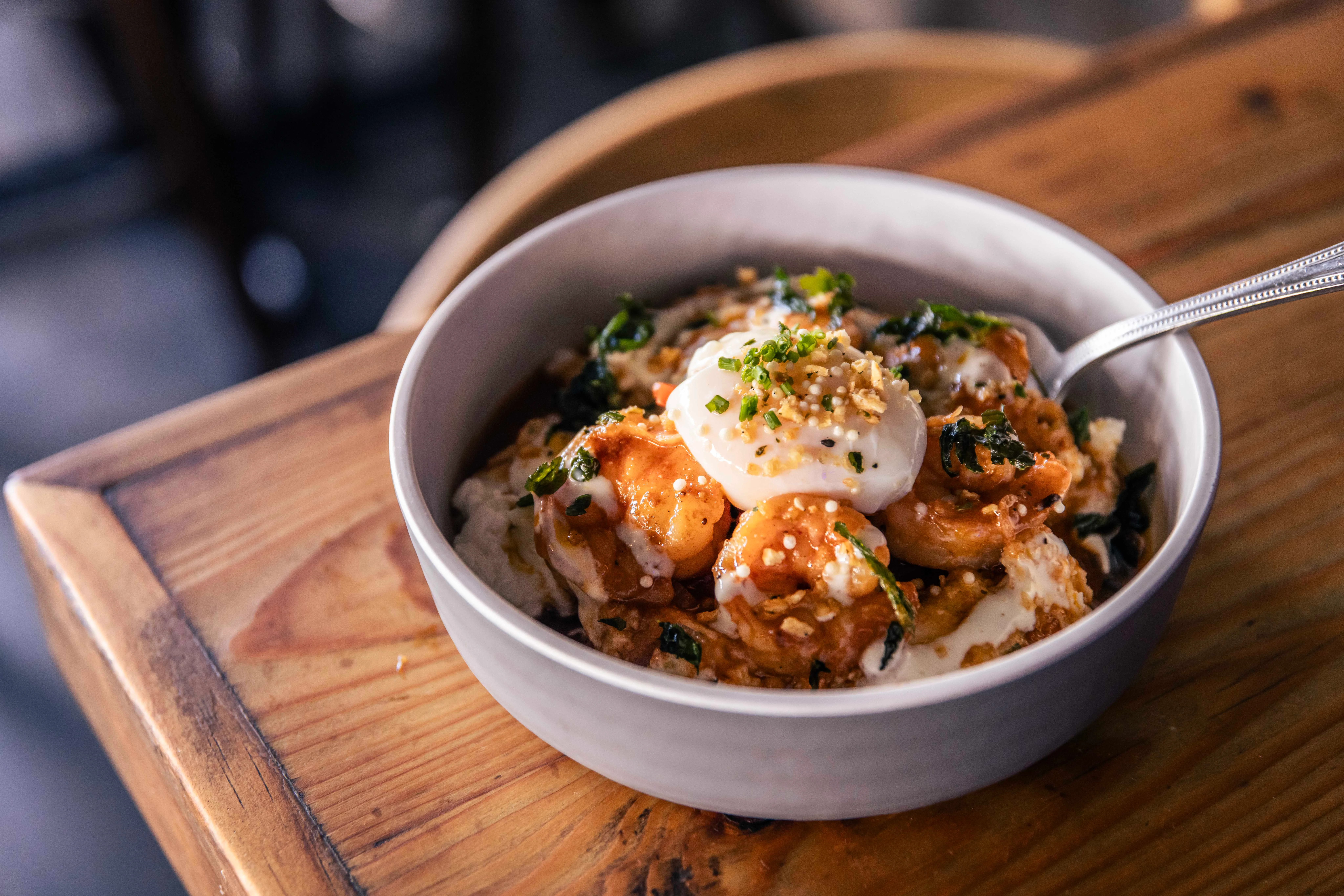 Bowl of Indian-style shrimp curry with yogurt and herbs