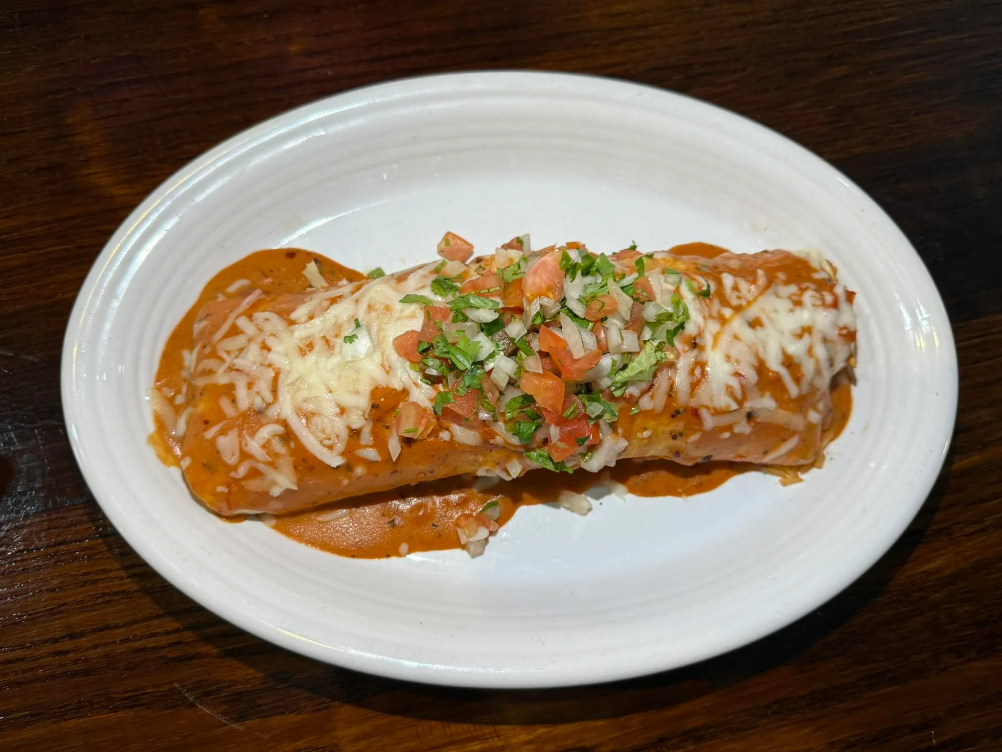 Delicious Mexican enchilada topped with cheese and fresh toppings