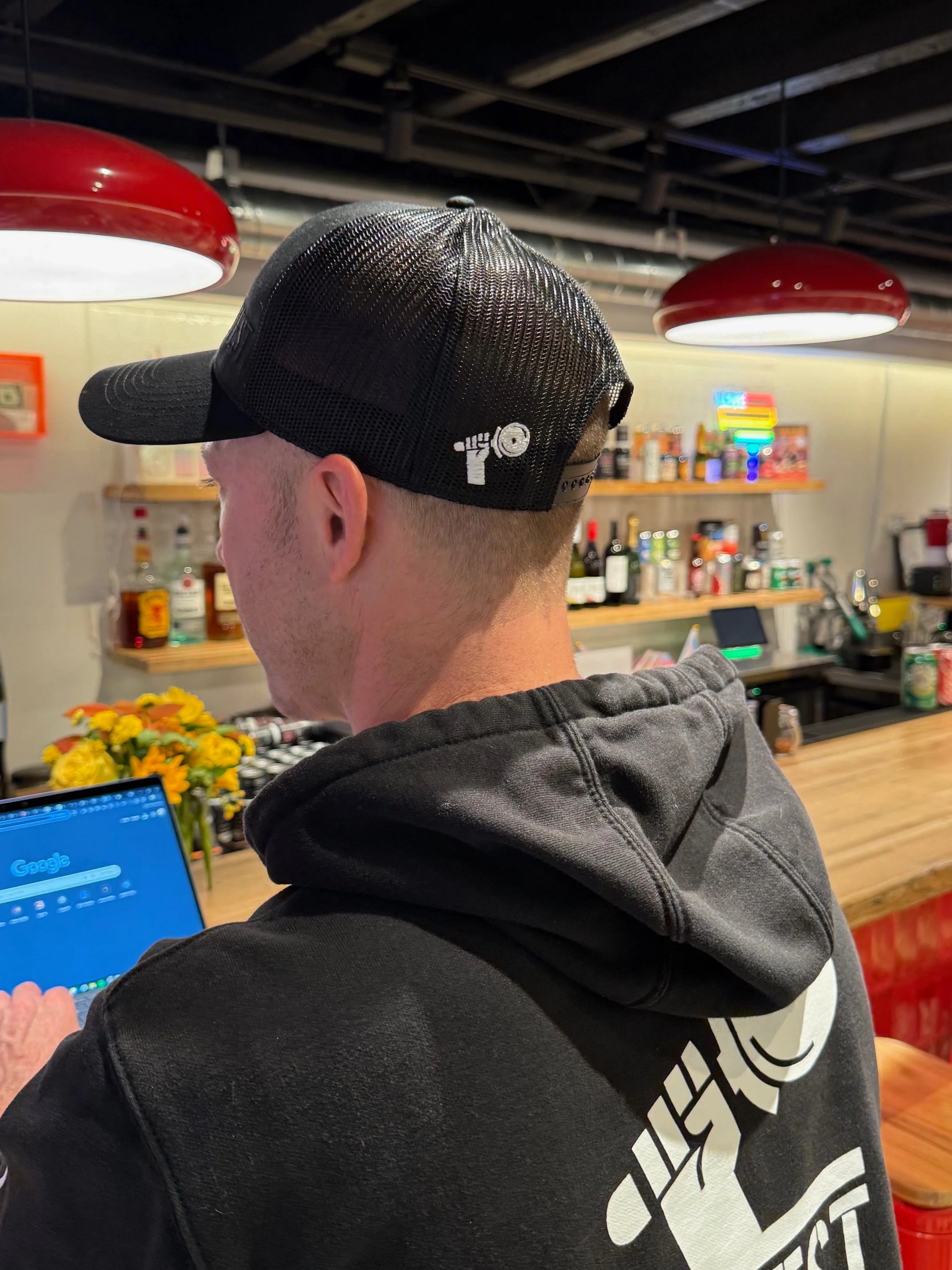 Bartender working on a laptop in a modern bar setting