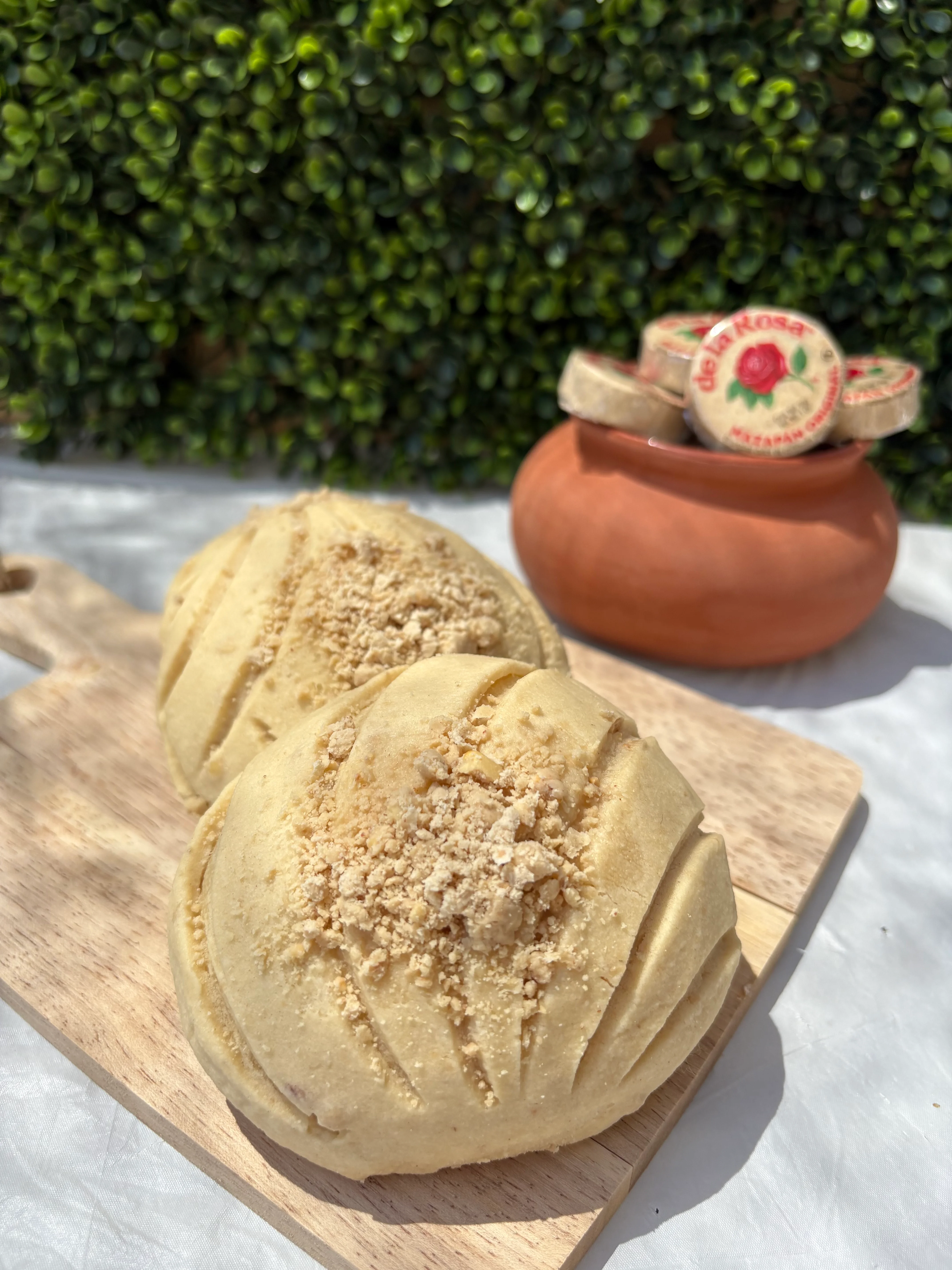Mexican concha bread with crumb topping on a wooden board