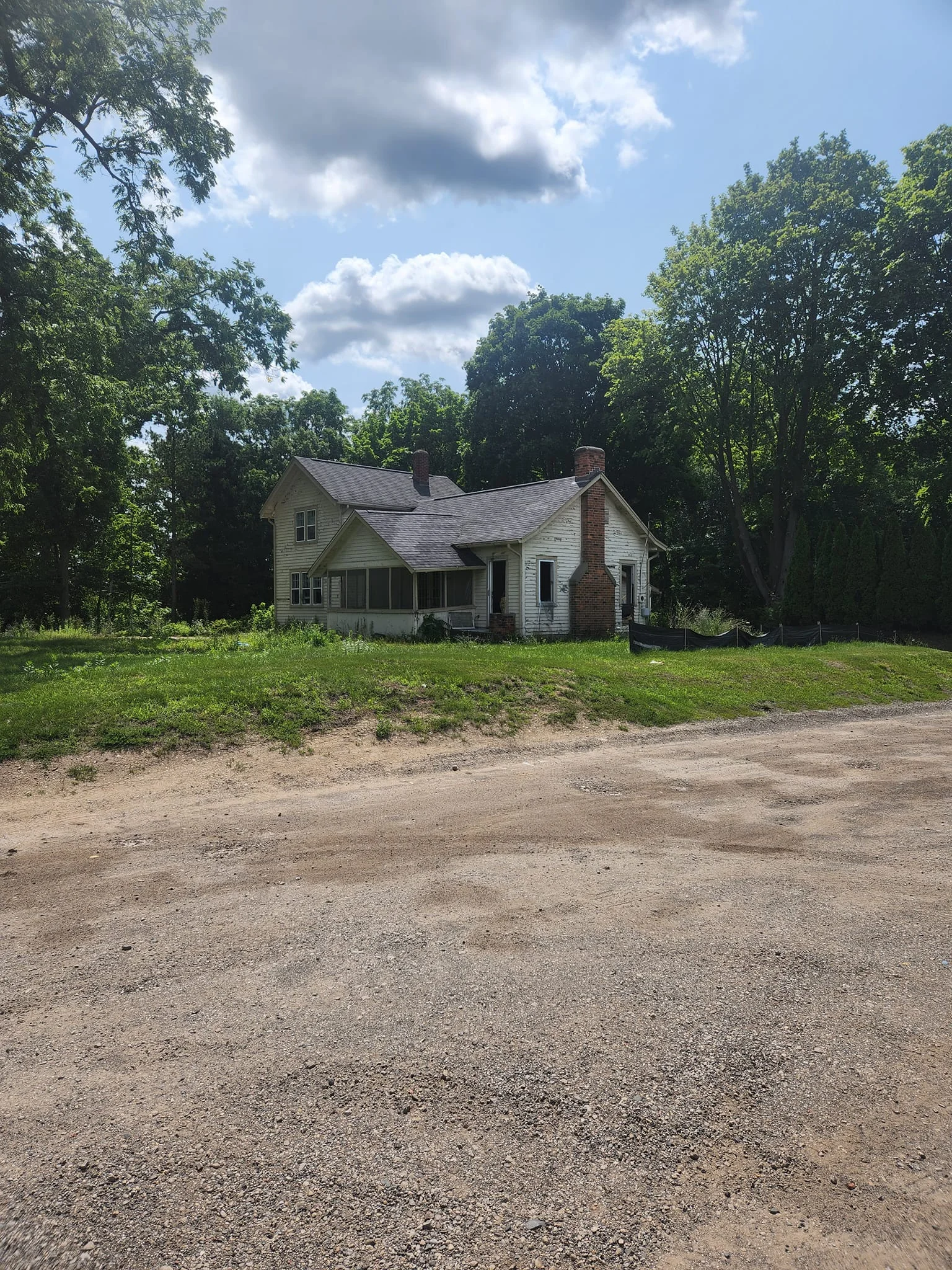 Abandoned house surrounded by trees on a sunny day