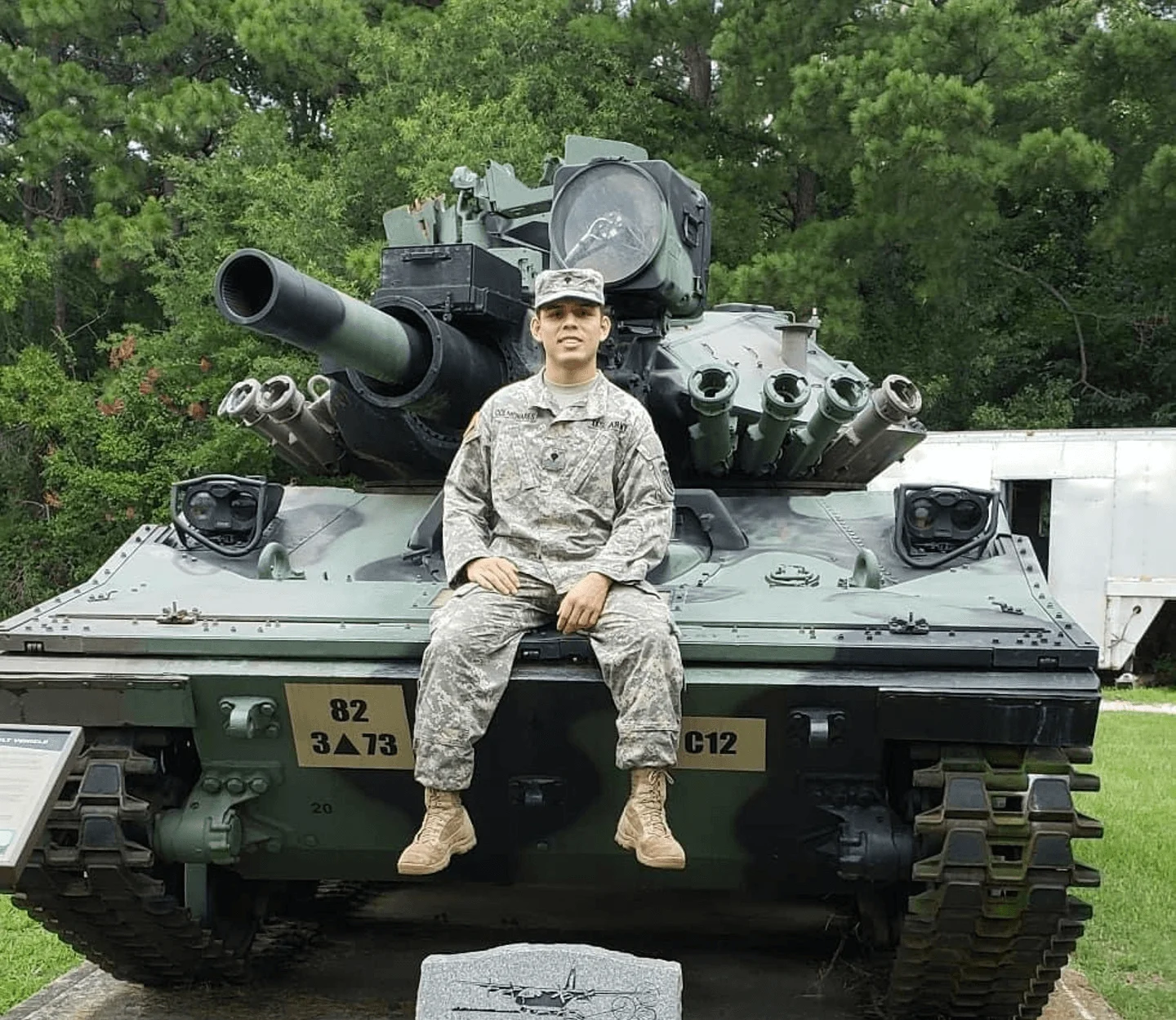 Soldier sitting on a military tank with dedication plaque