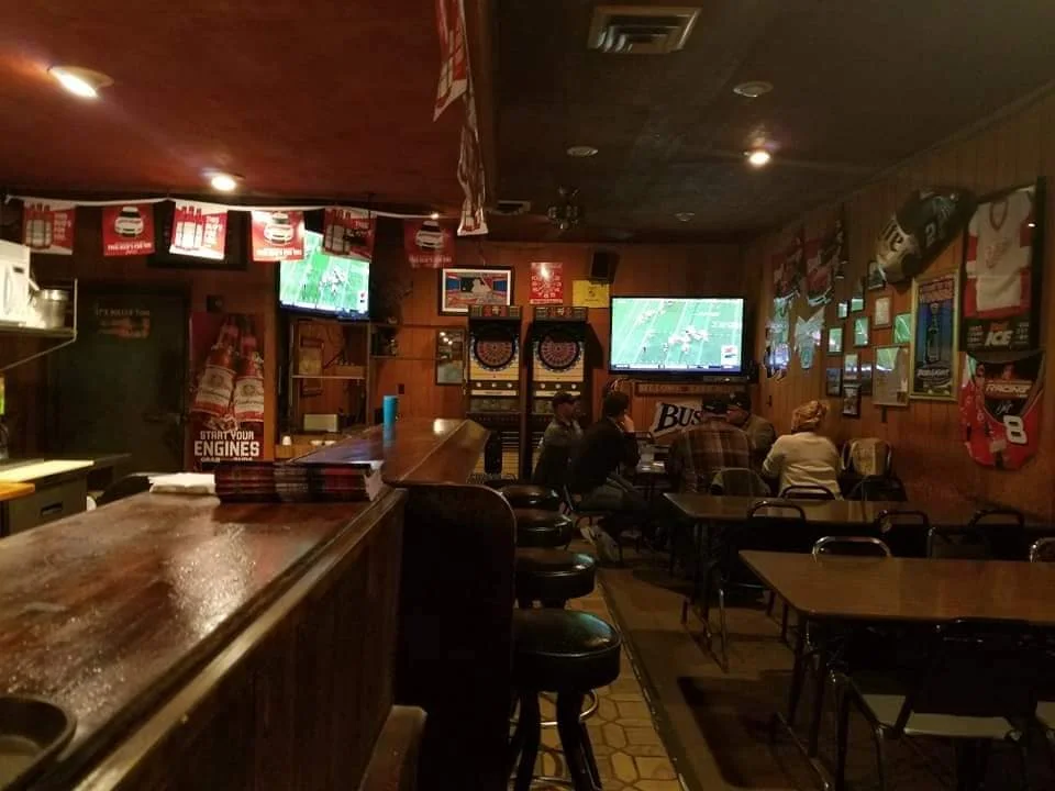 Cozy bar interior with dartboards and sports on TV