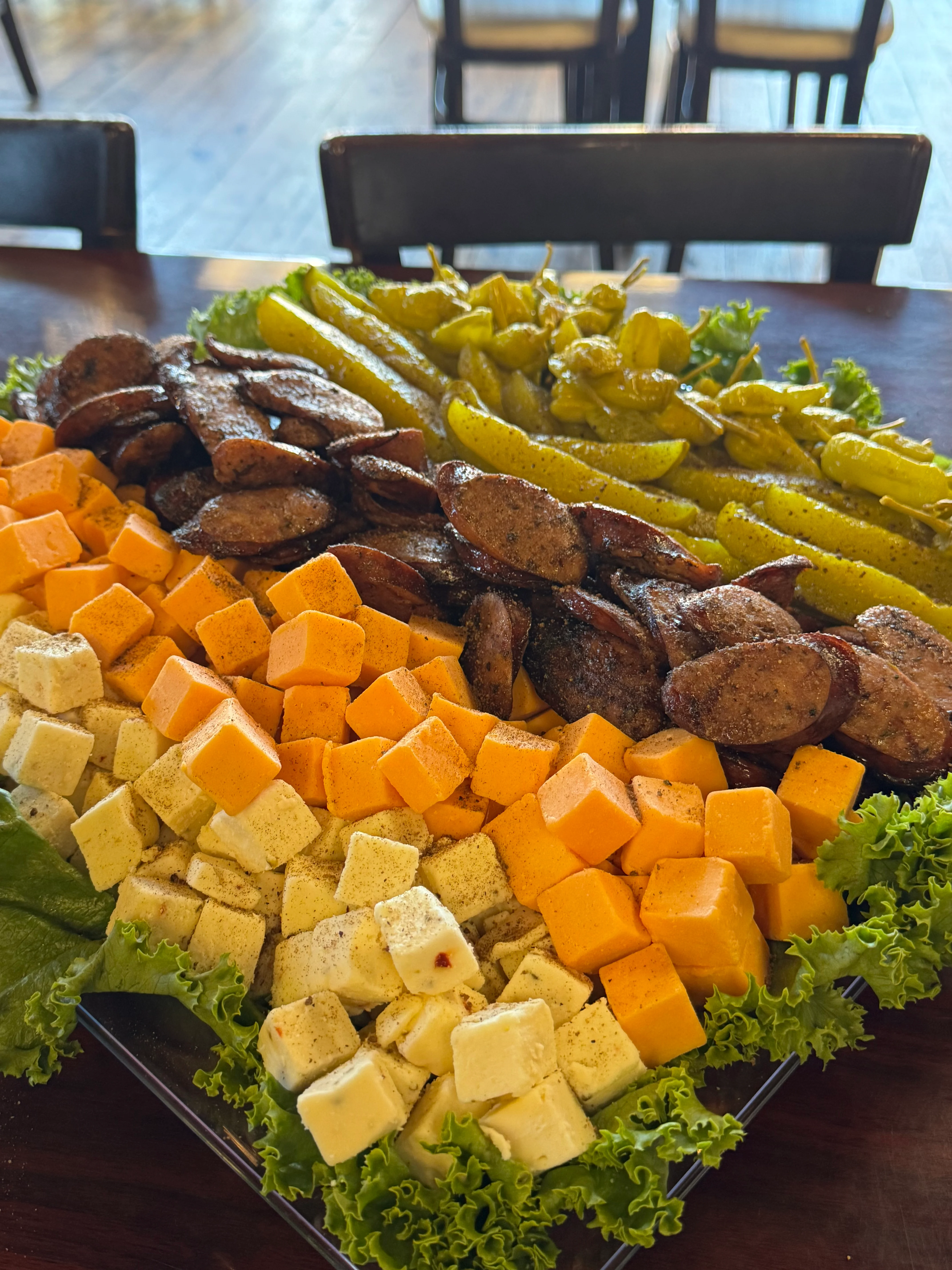 Charcuterie platter featuring assorted cheeses and smoked sausage