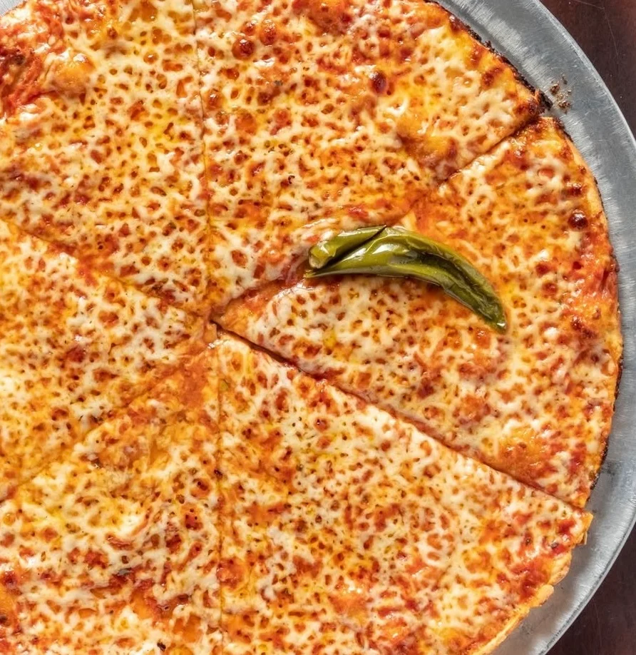 Cheese pizza with golden crust and green pepper garnish
