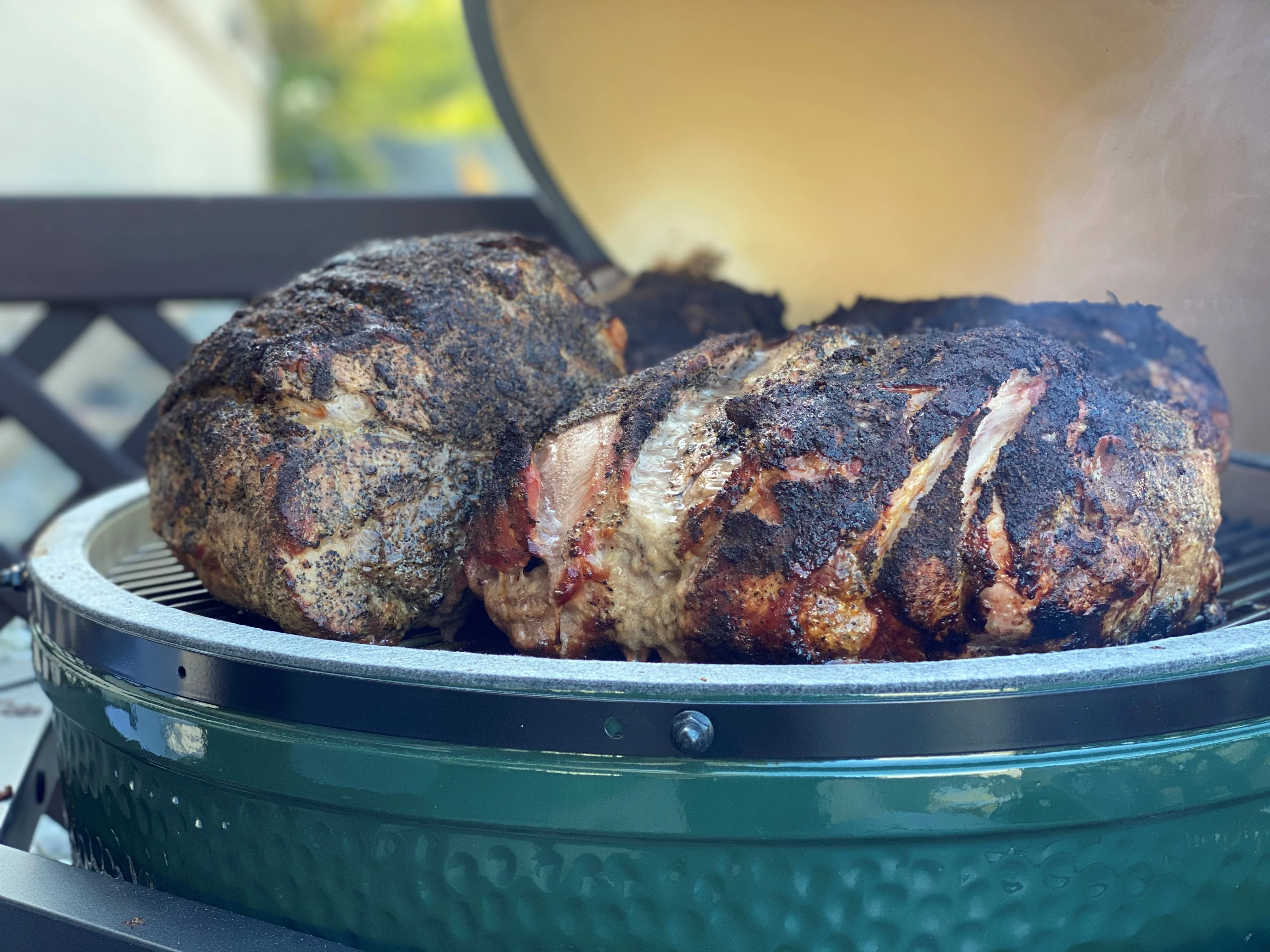 Smoked pork shoulder on a grill, showcasing barbecue cooking techniques