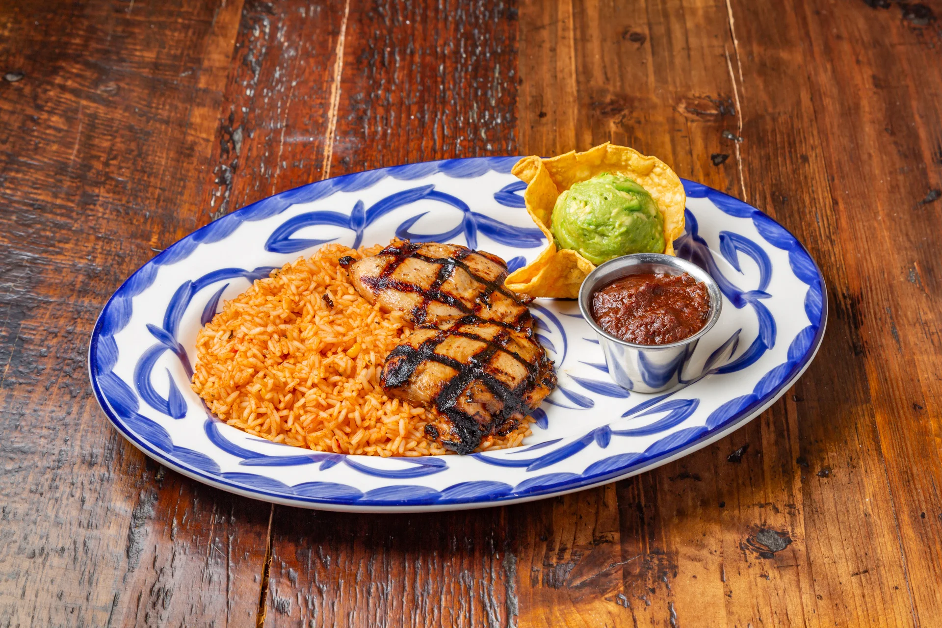 Chargrilled chicken dish served with fresh vegetables and garnishes.