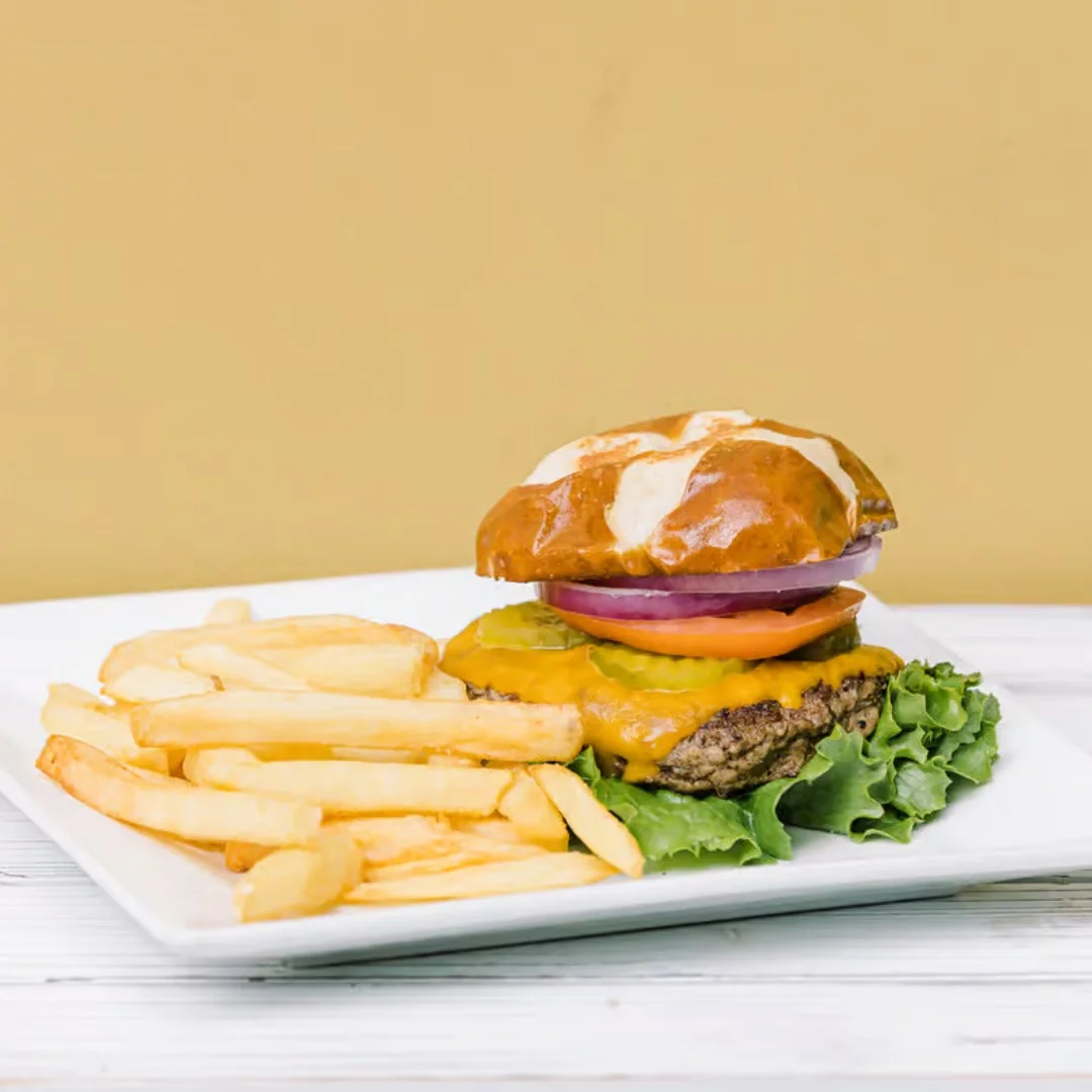 Juicy cheeseburger with fries on a white plate