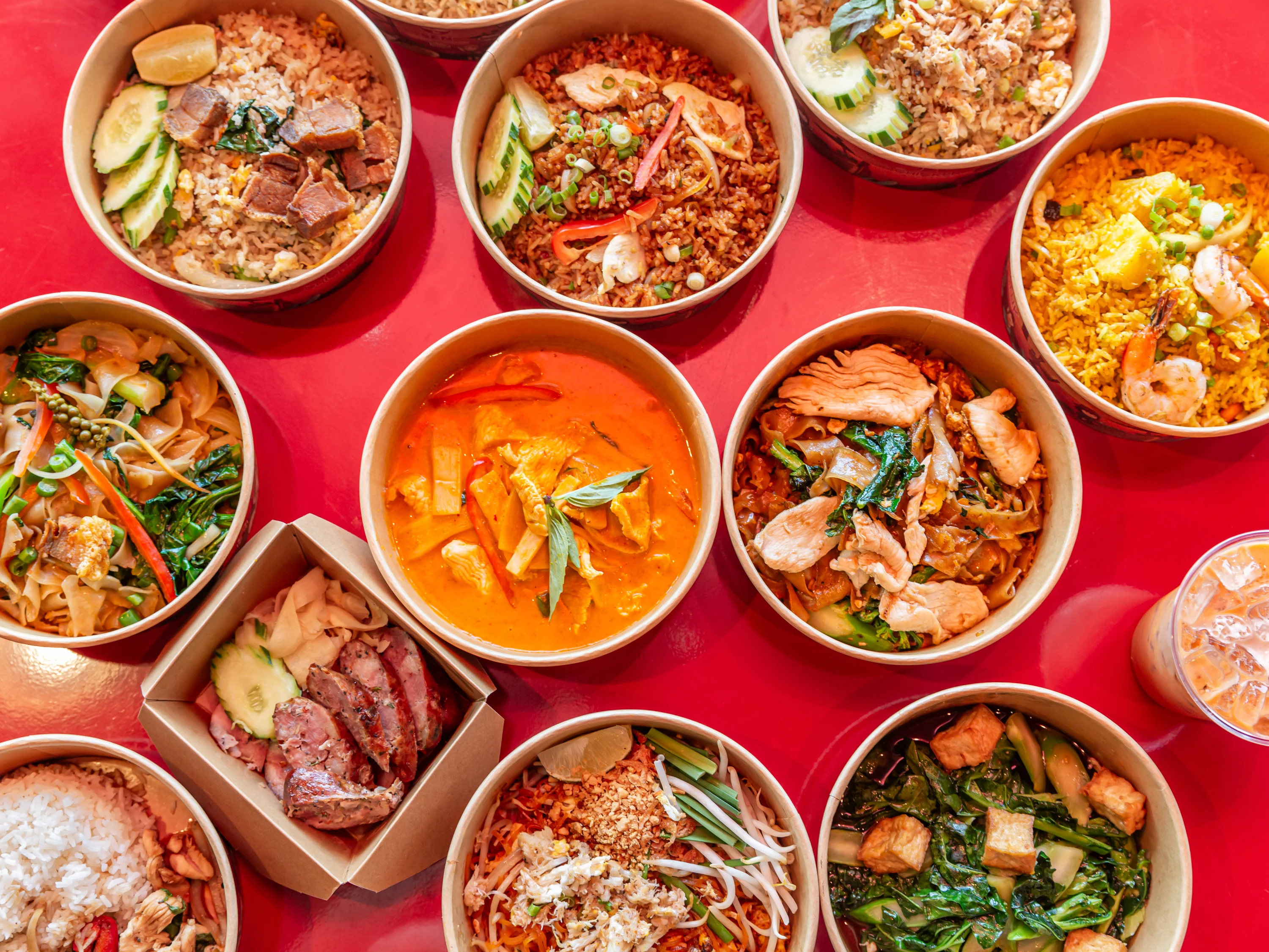 Assorted Thai dishes in bowls including curry and stir-fried noodles