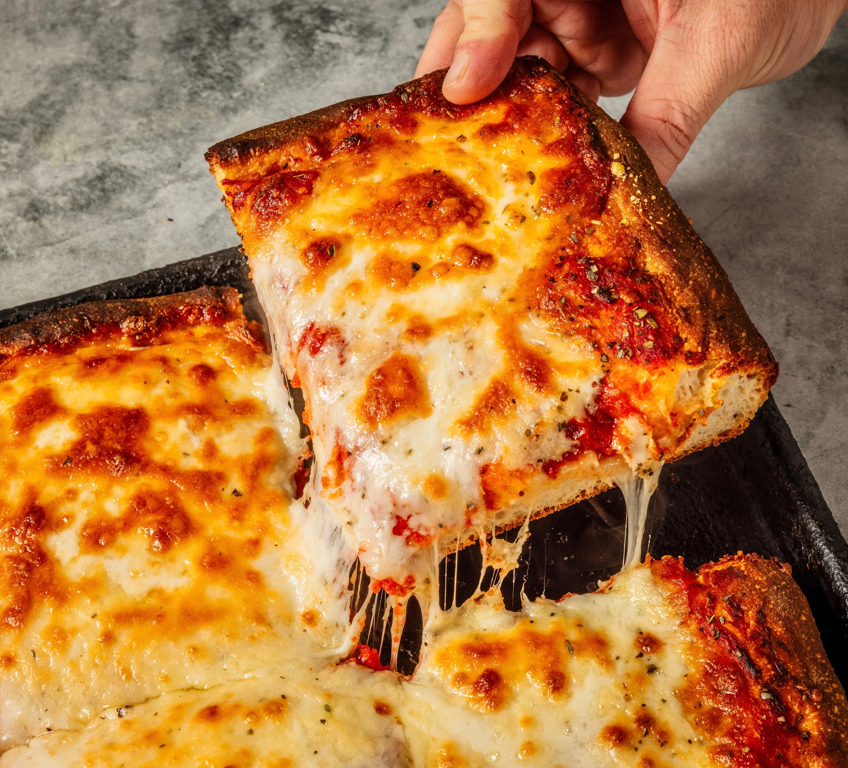 Thick Sicilian slice with melted mozzarella
