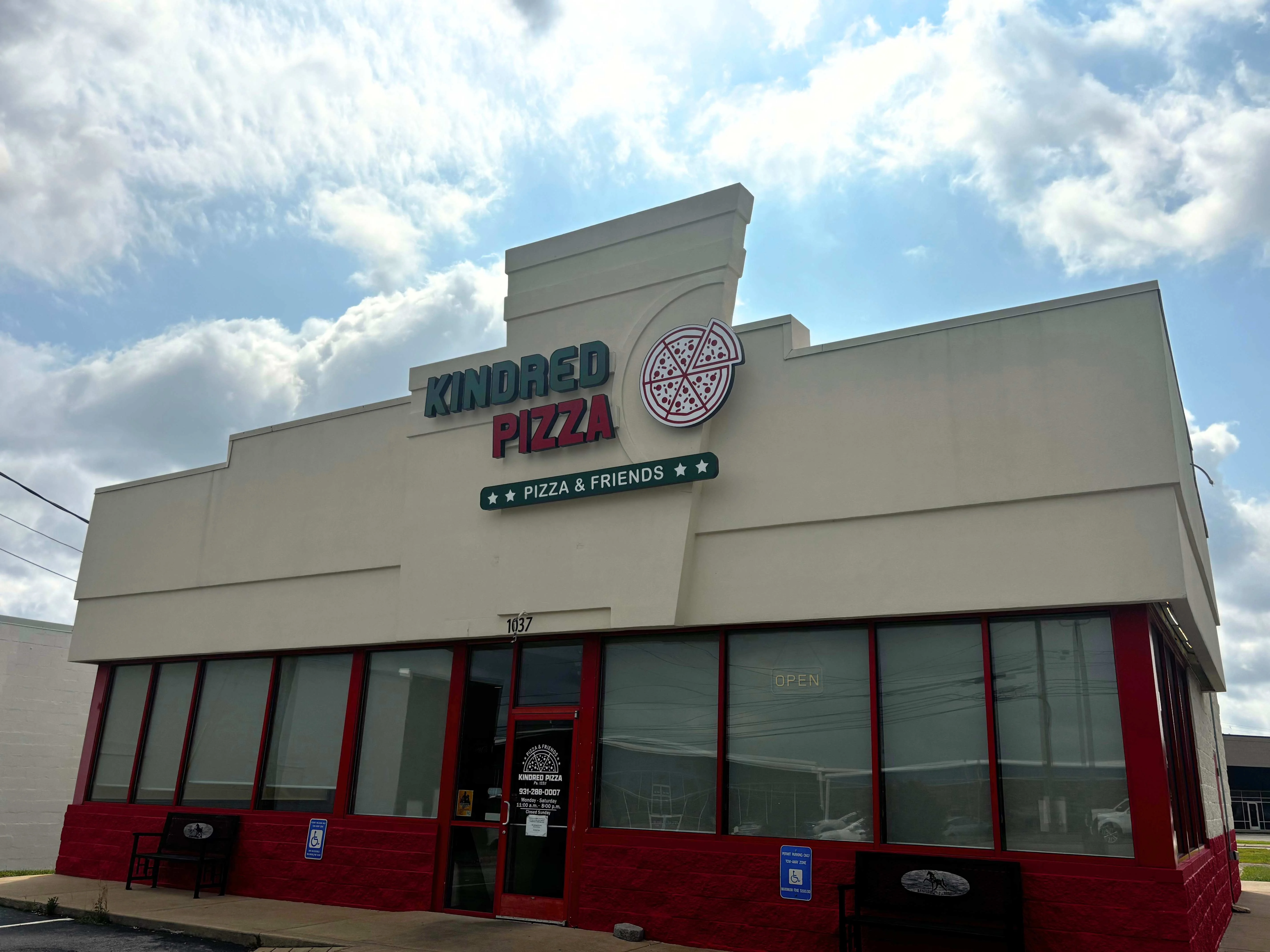 Exterior view of Kindred Pizza restaurant with bright signage