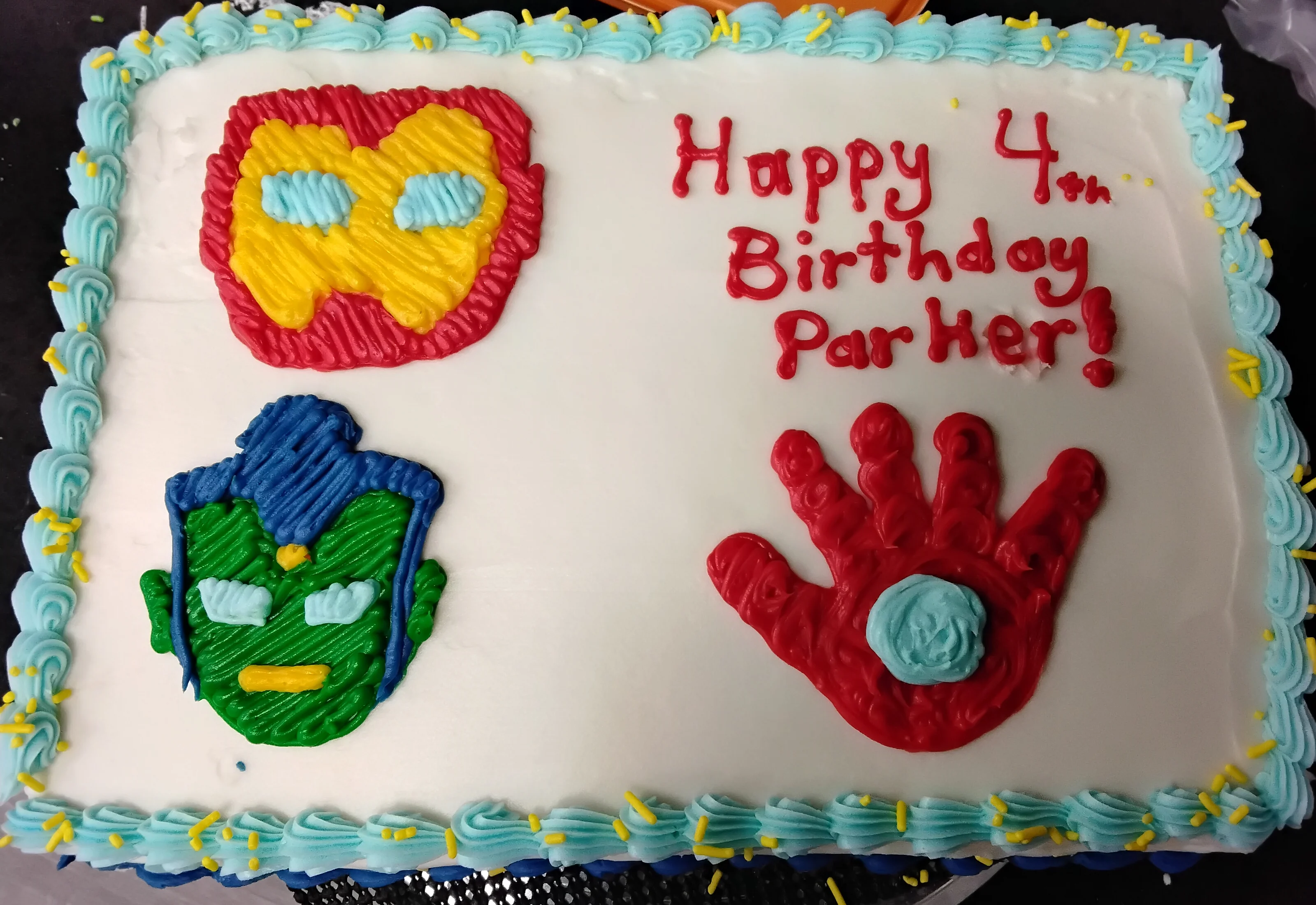 Sheet cake with light blue border and the Hulk and Iron Man mask & hand drawn in icing that says "Happy 4th Birthday Parker!"