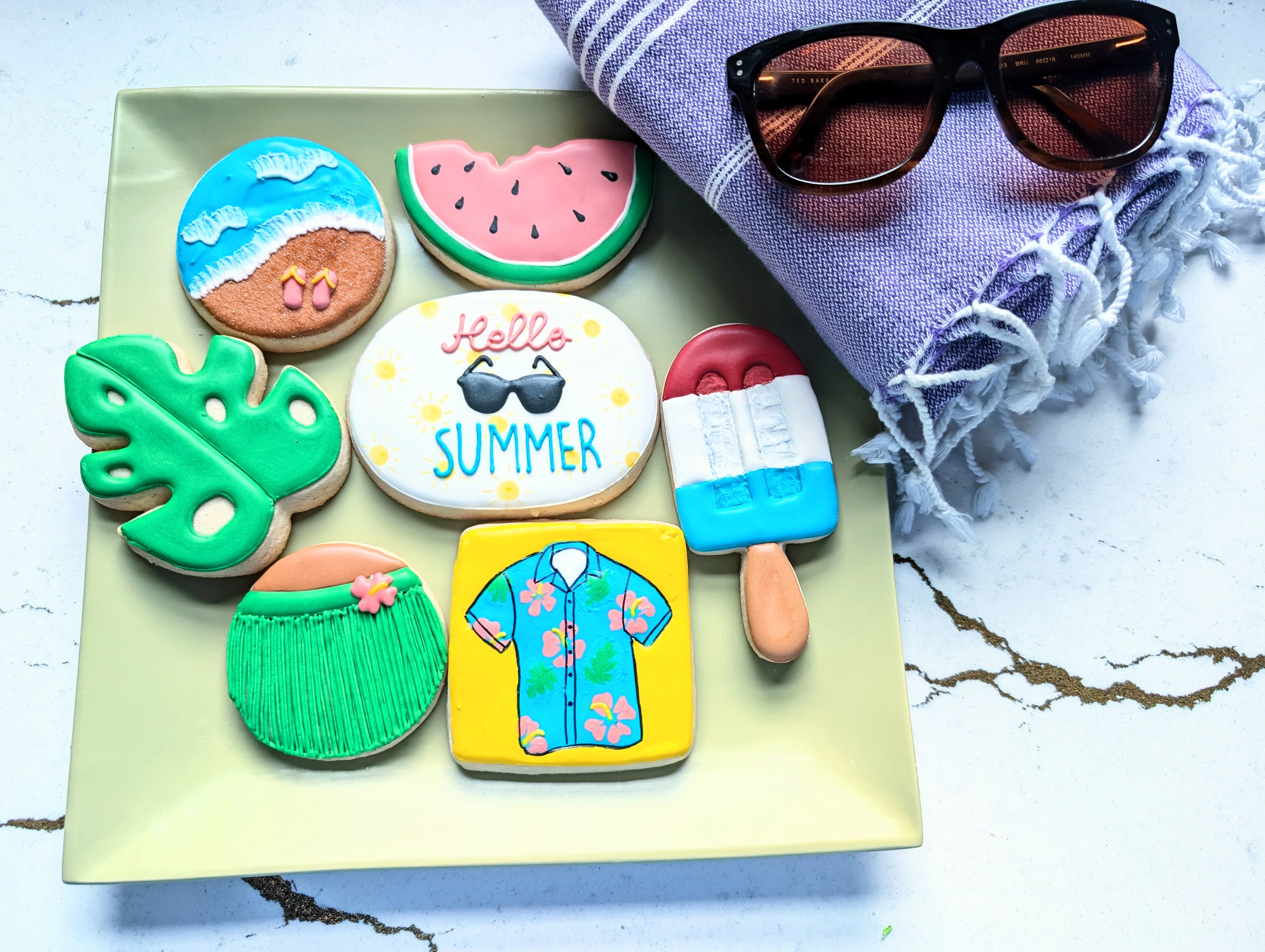 Colorful summer-themed decorated cookies on a plate