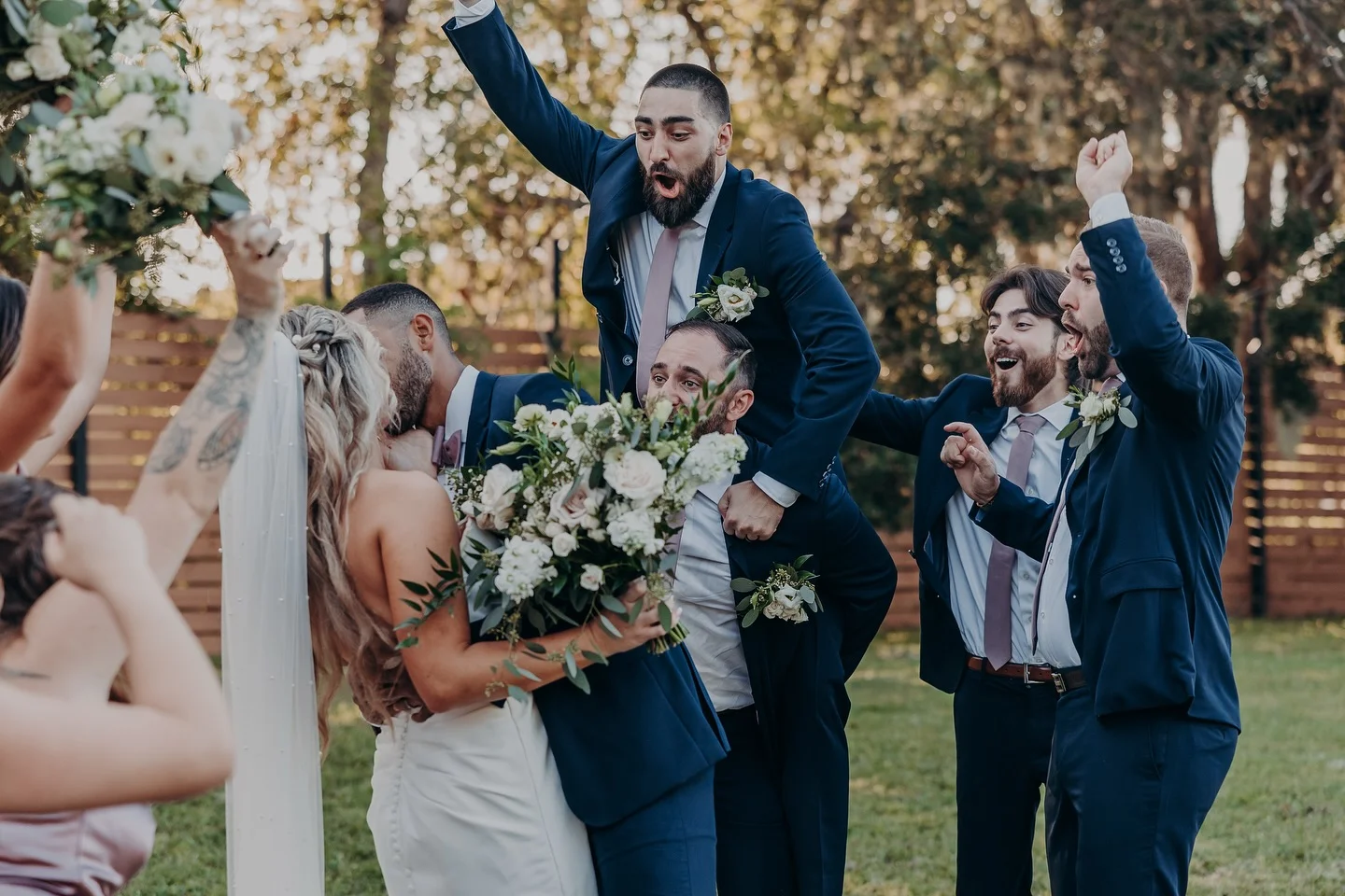 Joyful wedding celebration with guests cheering and embracing the couple