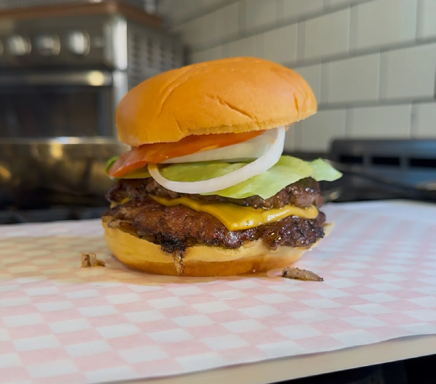 Juicy burger with lettuce, tomato, and cheese on a wooden table