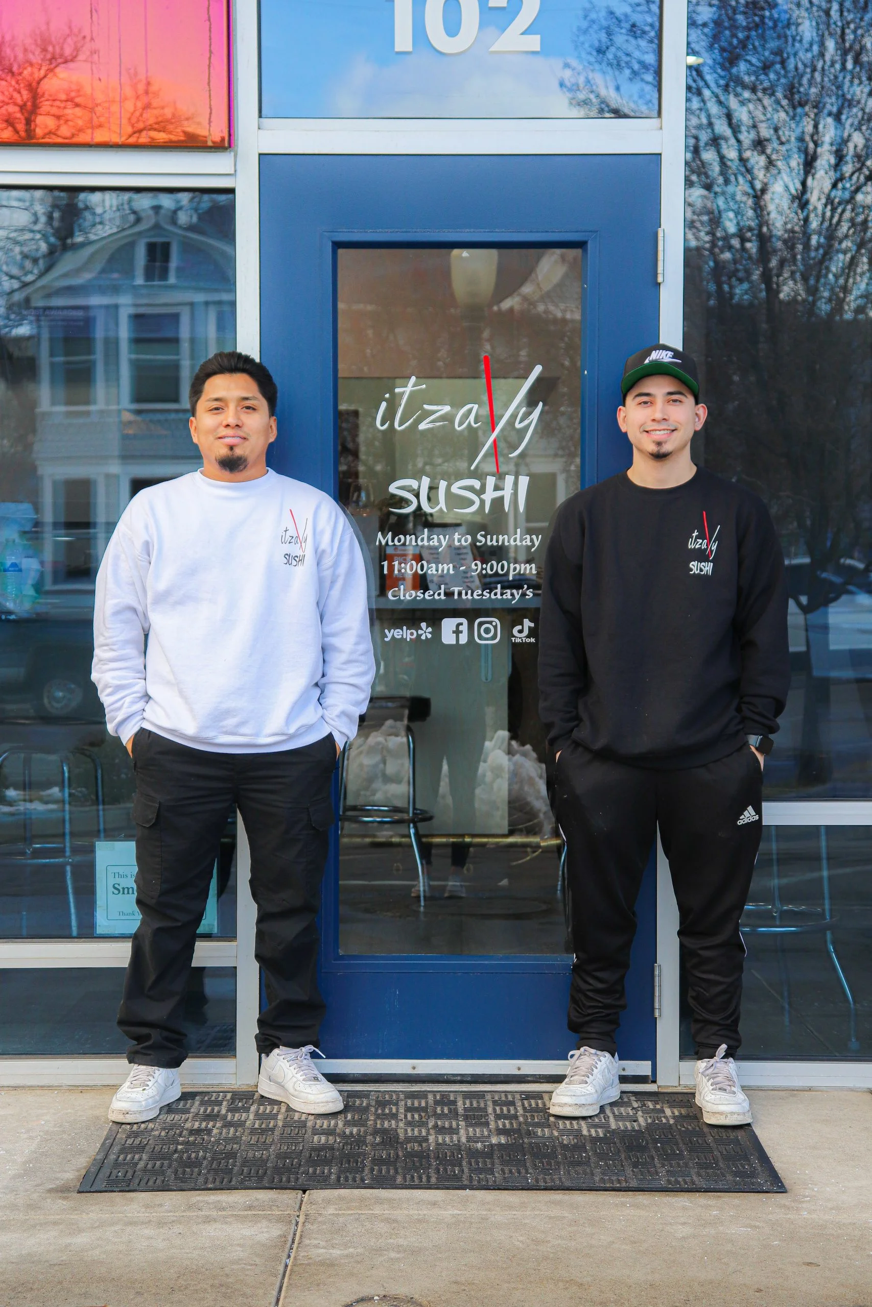 Two chefs standing outside Itzaly Sushi restaurant