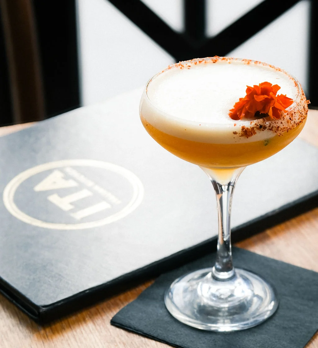 Craft cocktail garnished with a flower in a stylish glass