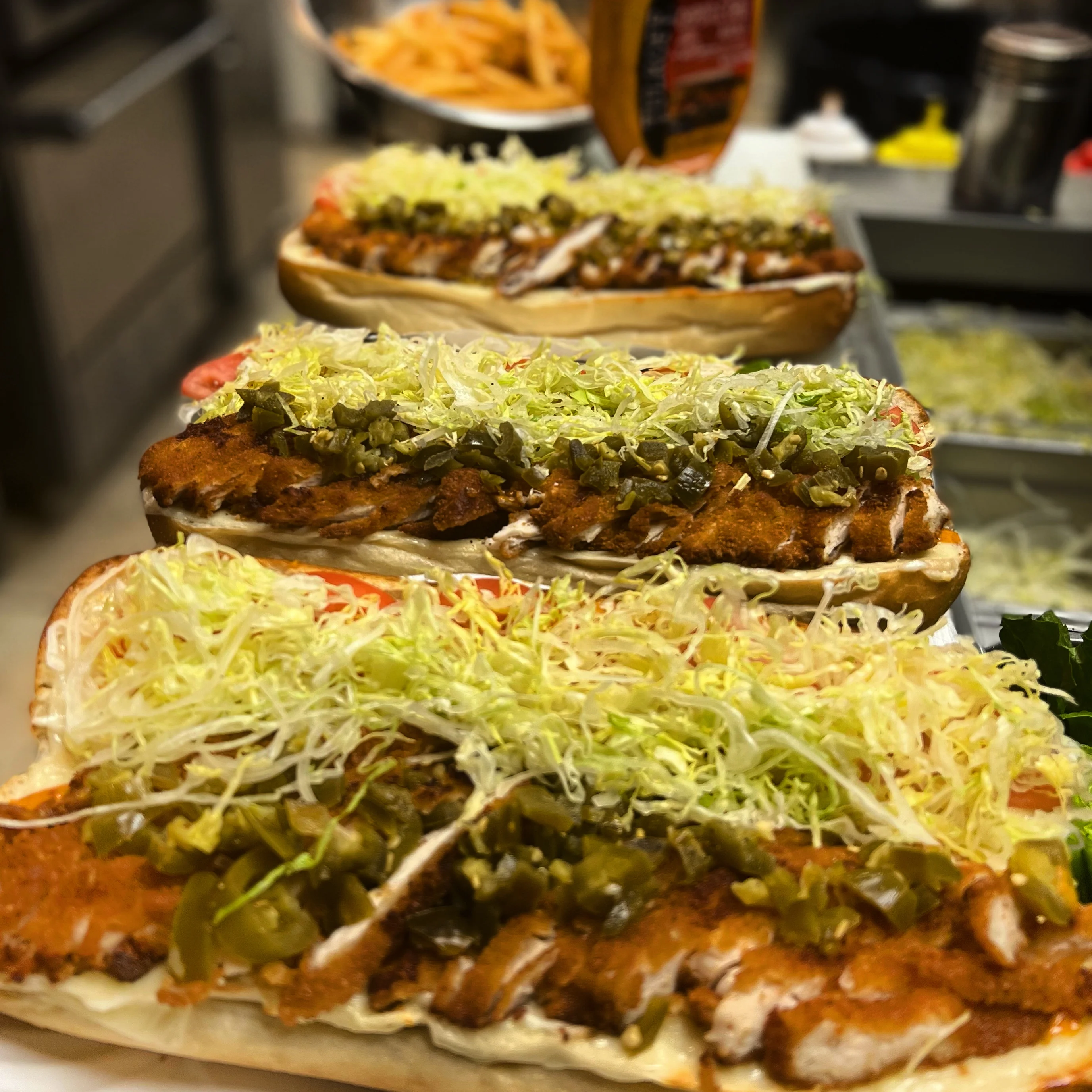 Crispy chicken hoagies topped with lettuce and pickles