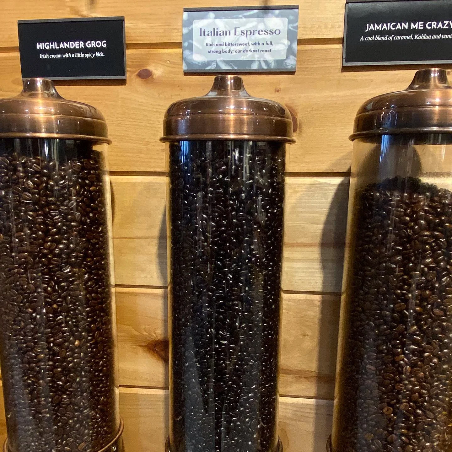 Variety of coffee beans in glass containers at a coffee shop