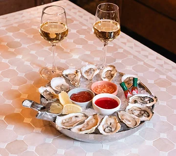 Fresh oysters on ice with dipping sauces and white wine