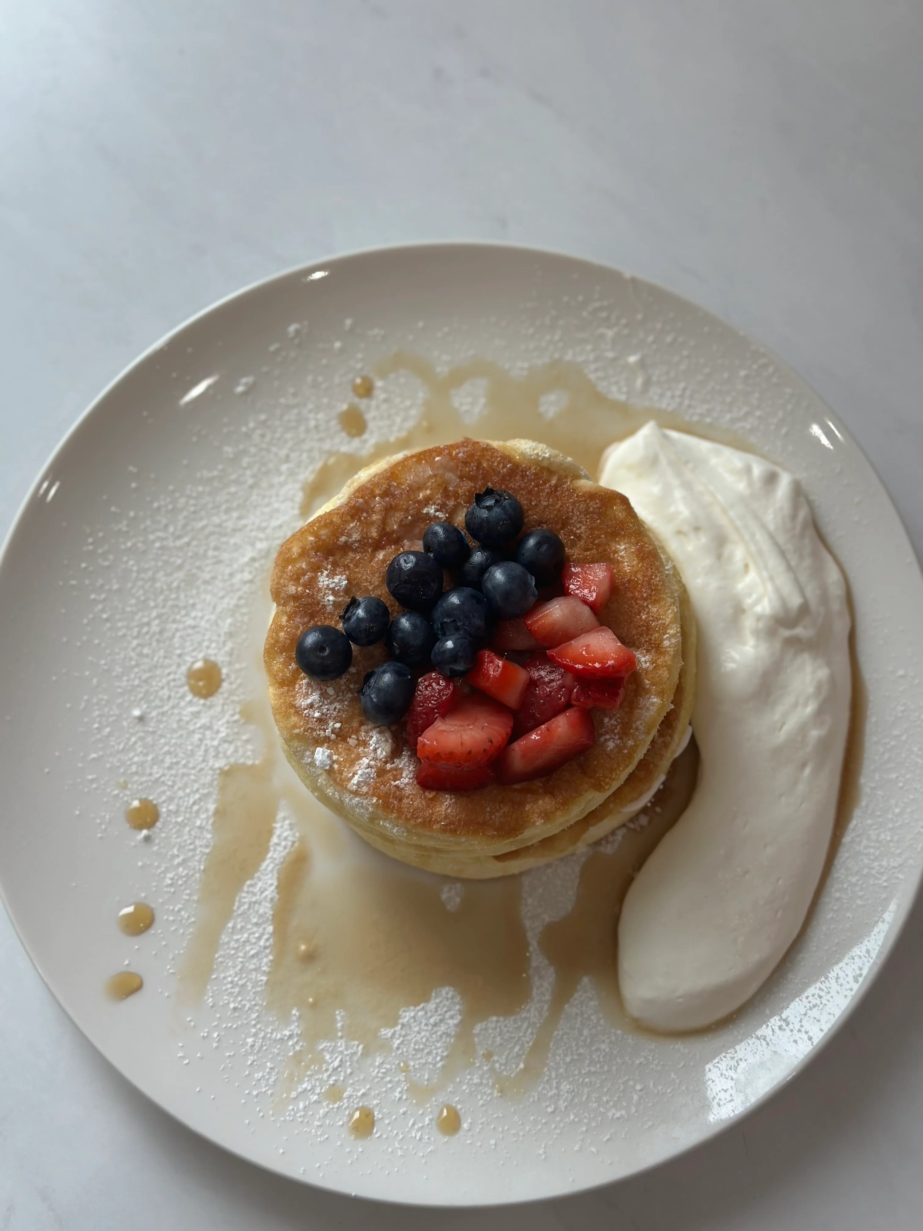 Fluffy Japanese pancakes topped with berries and cream