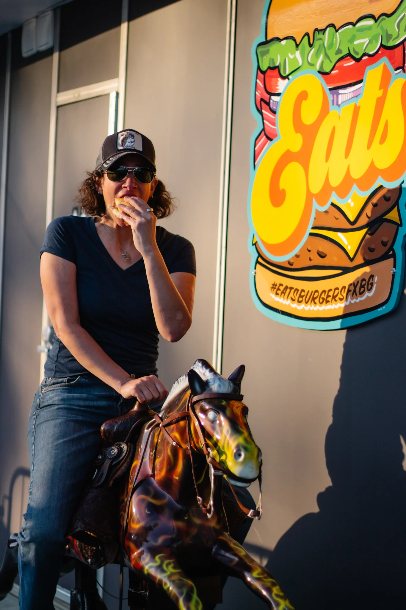 Person enjoying a burger at a vibrant eatery with playful decor