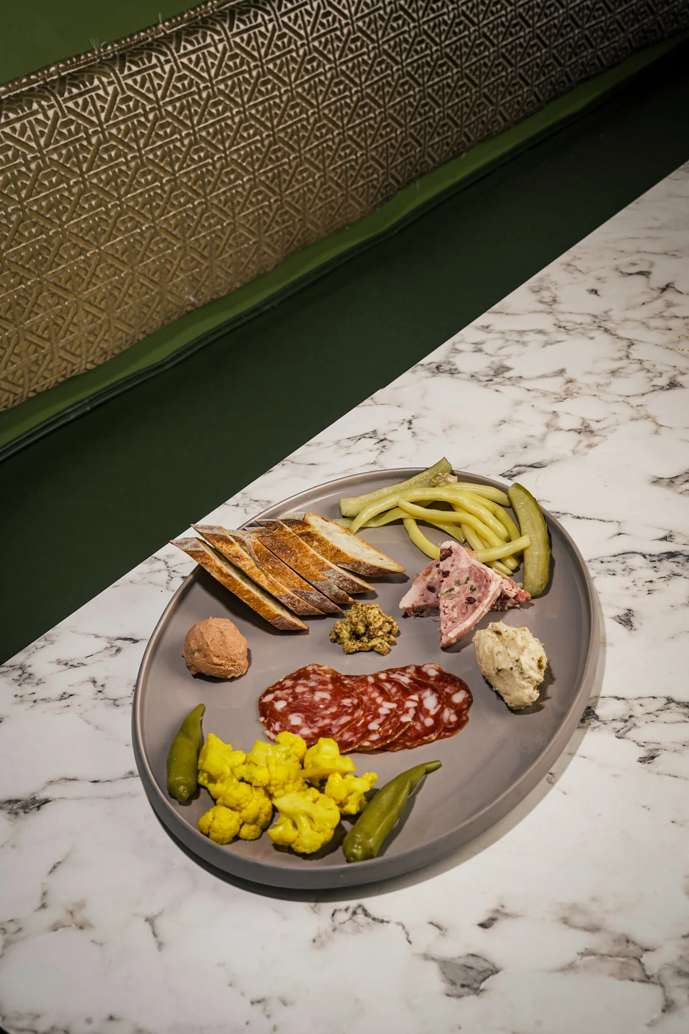 Charcuterie platter featuring assorted meats and pickled vegetables
