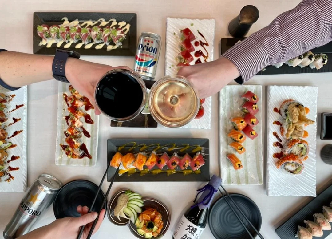 Japanese sushi platter with assorted rolls and drinks