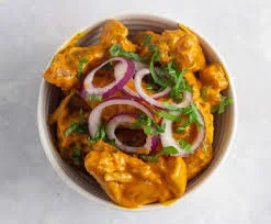 Creamy Indian butter chicken served with onions and cilantro