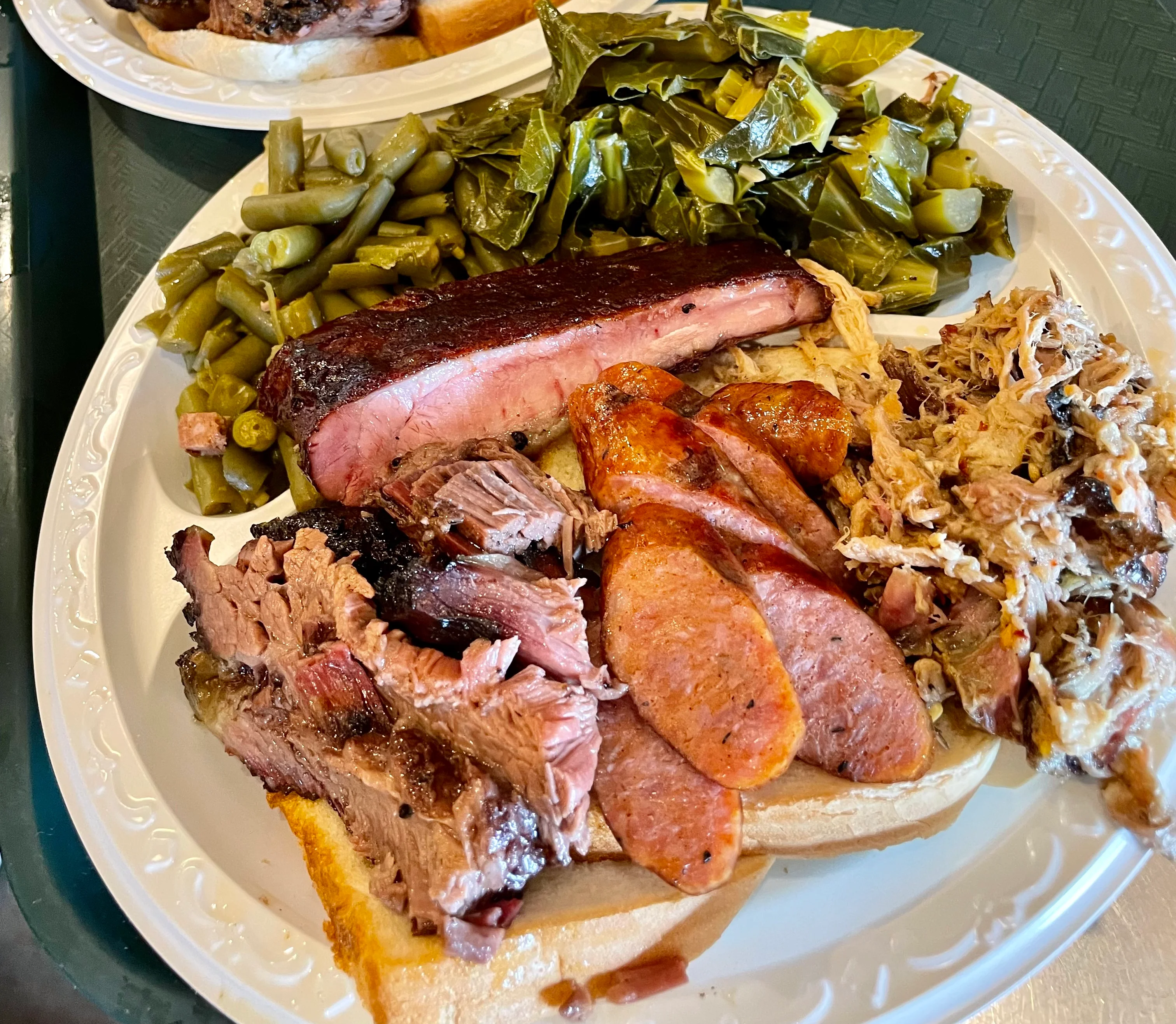 Platter of brisket, pulled pork, sausage, and ribs with green beans