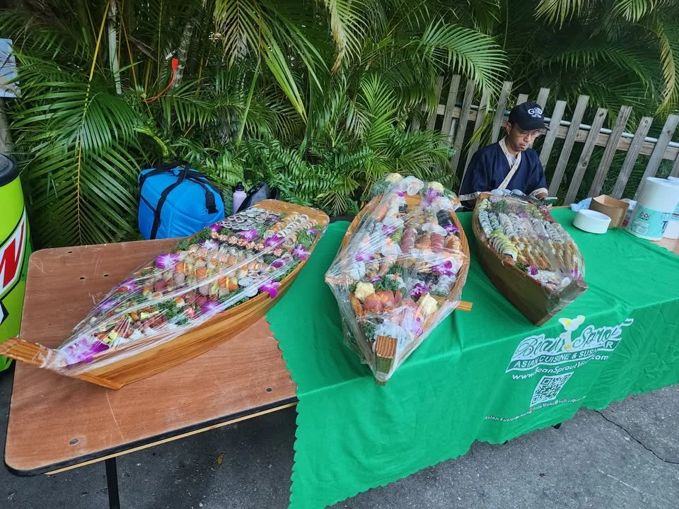 Assorted sushi platters displayed at an outdoor Japanese food stall