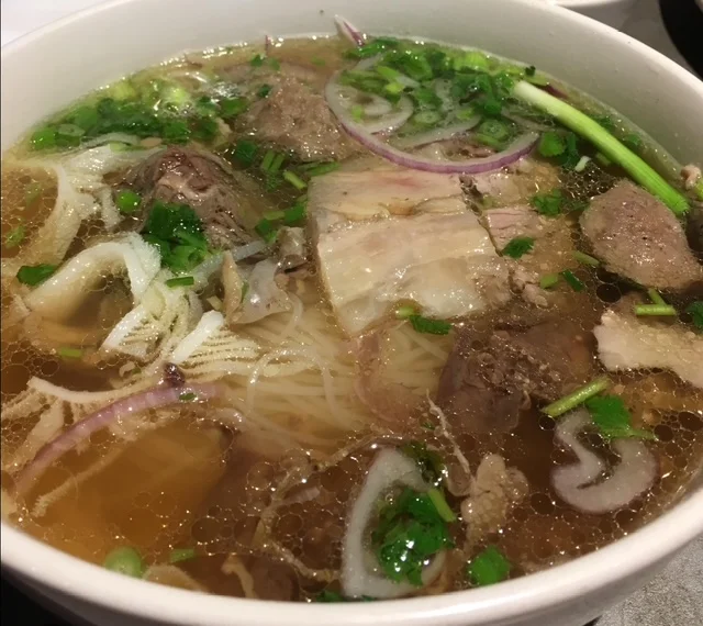 Bowl of Vietnamese pho with beef and fresh herbs