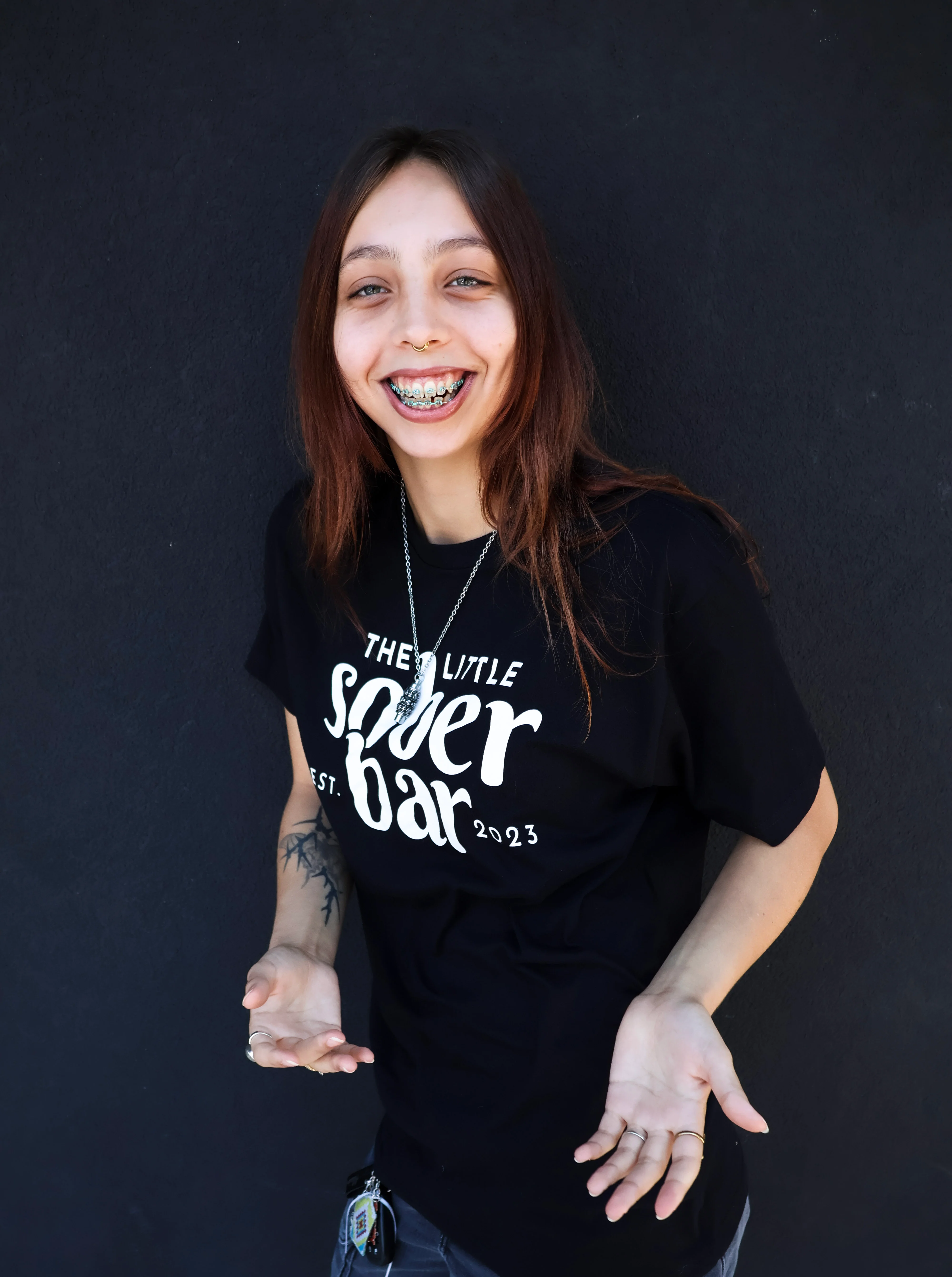 Portrait of restaurant staff member wearing branded bar shirt